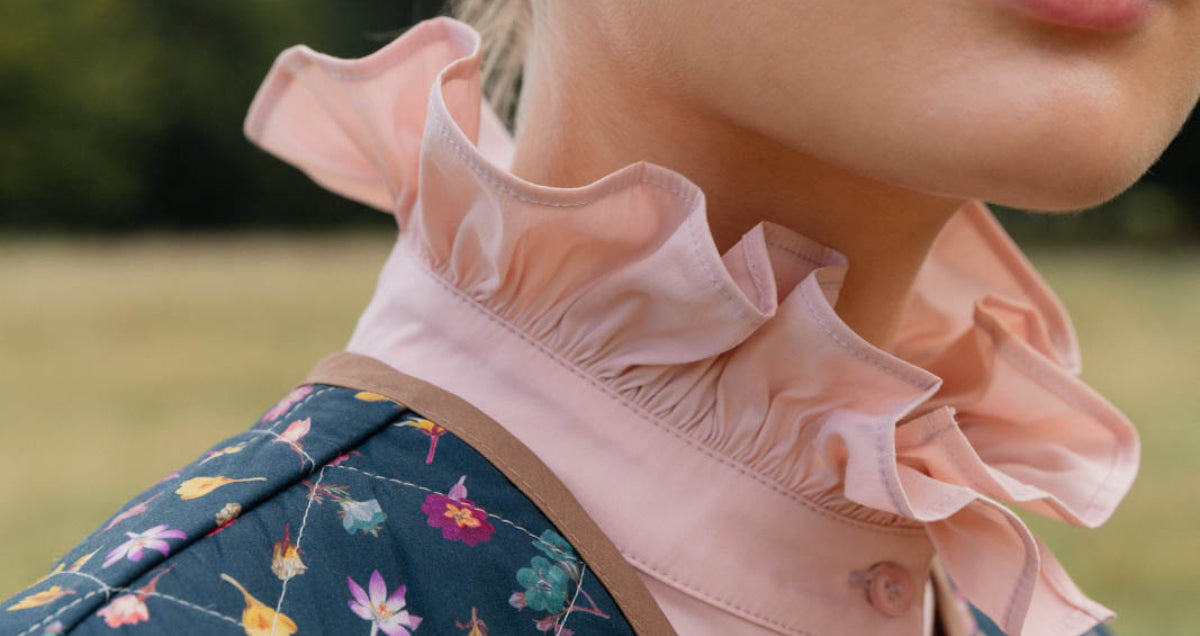 Woman in pink cotton shirt with frilled stand collar