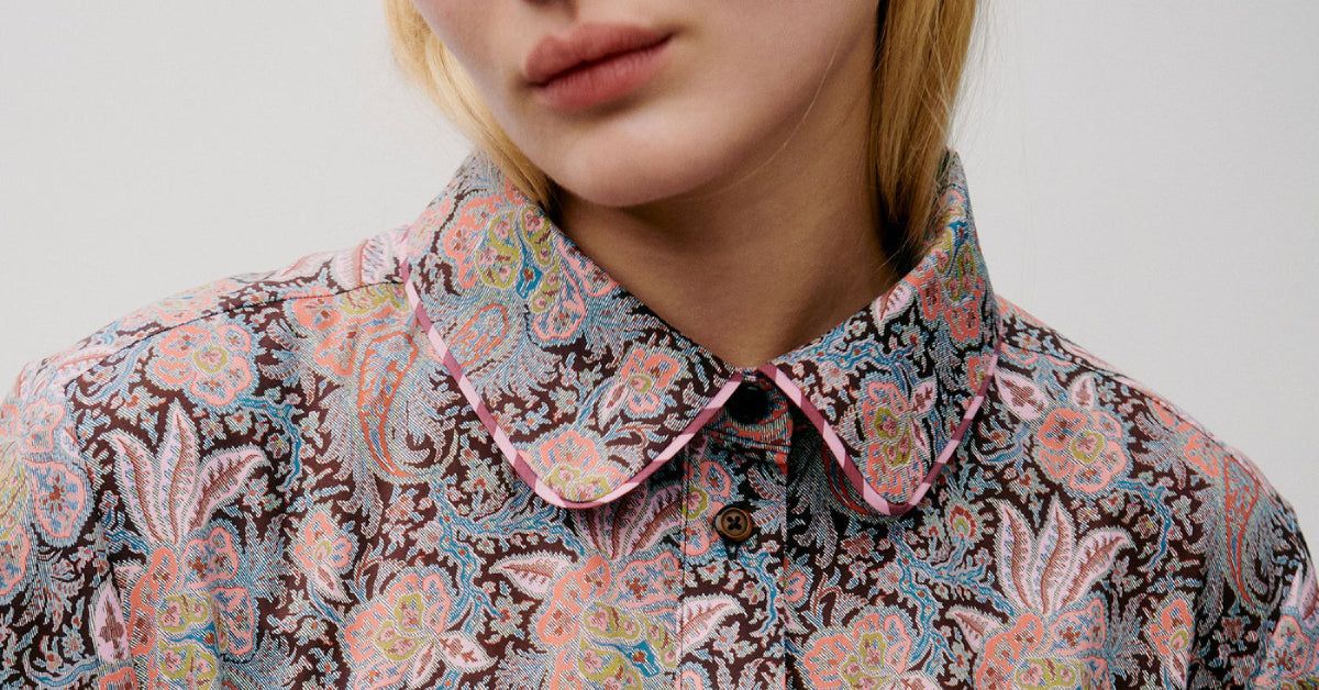 Woman in paisley patterned long dress with collar and buttons
