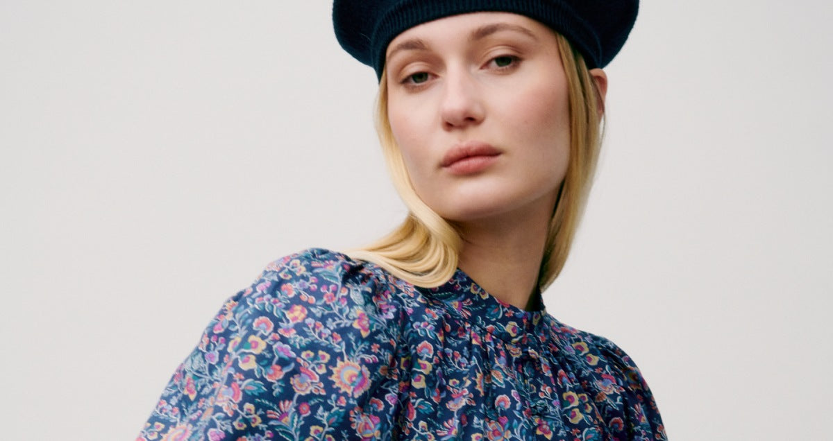 Woman in blue and pink floral patterned shirt with puss sleeves