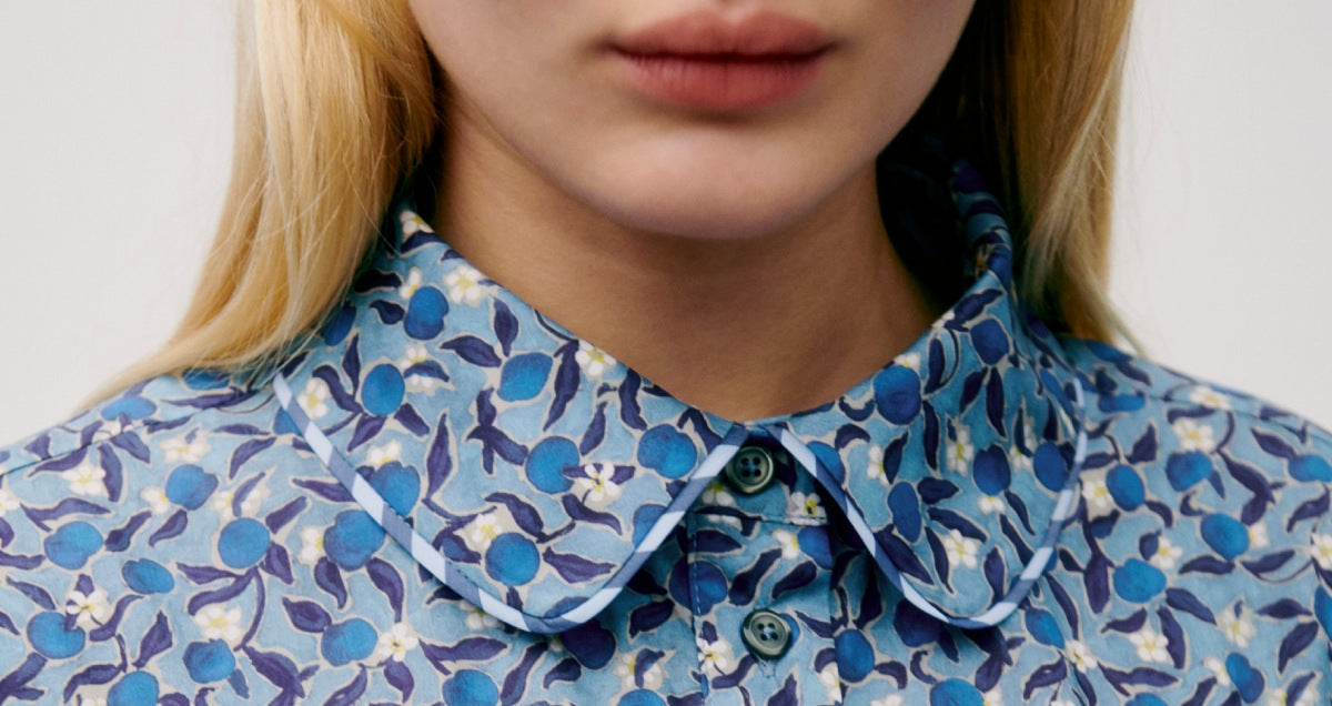 Woman in blue floral print dress with classic collar