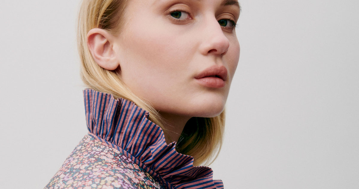 Woman in red and white striped summer shirt with stand collar and floral pipings