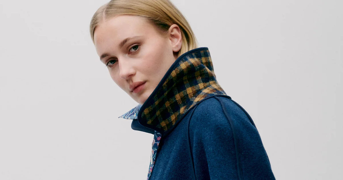 Woman in dark blue and checked wool coat with stand collar