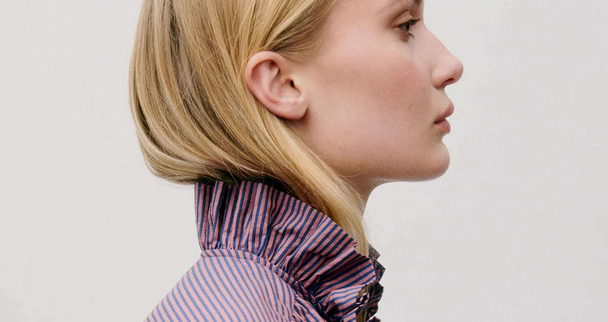 Woman in purple striped seersucker shirt with frilled stand collar