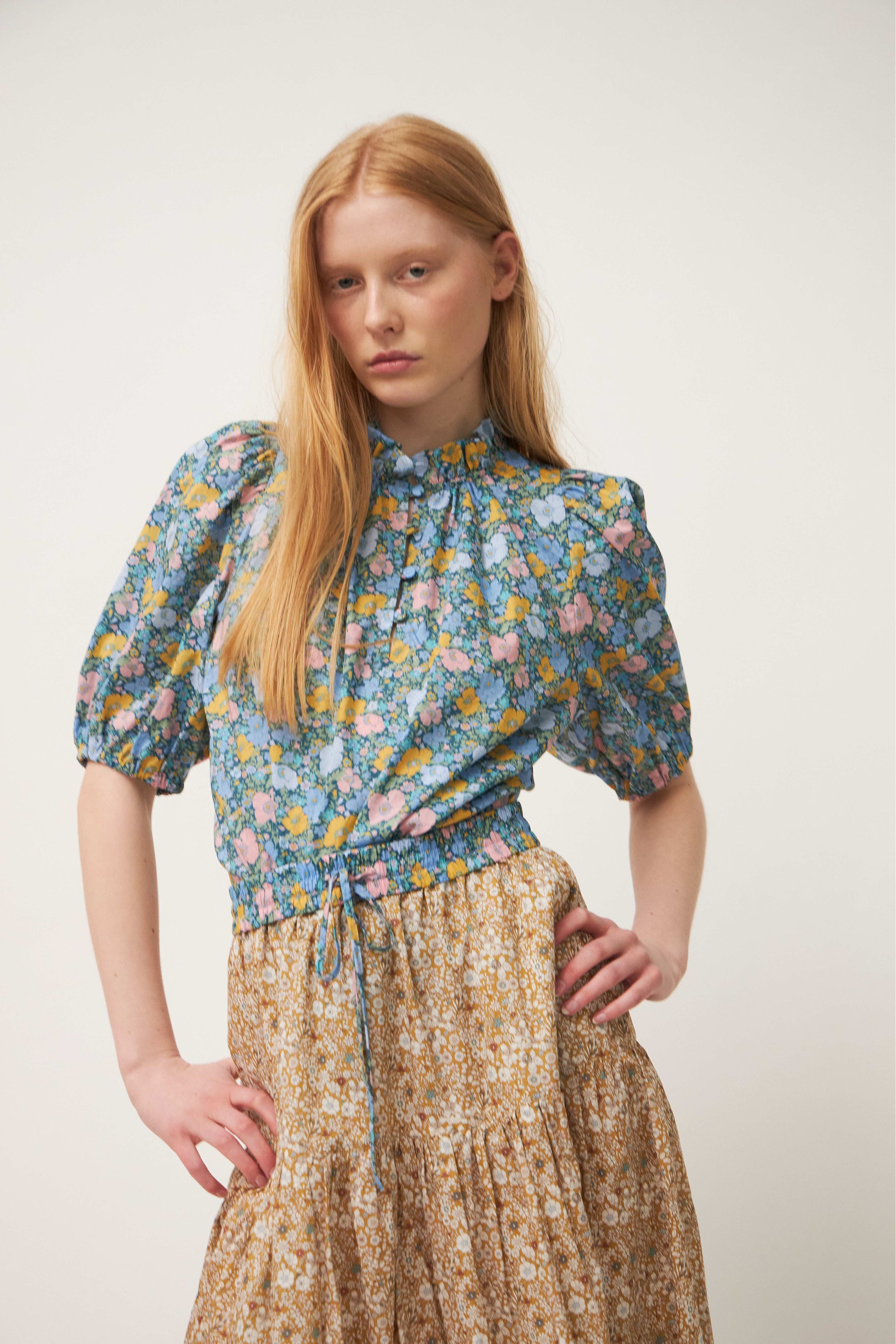 Woman in flower patterned blouse and skirt