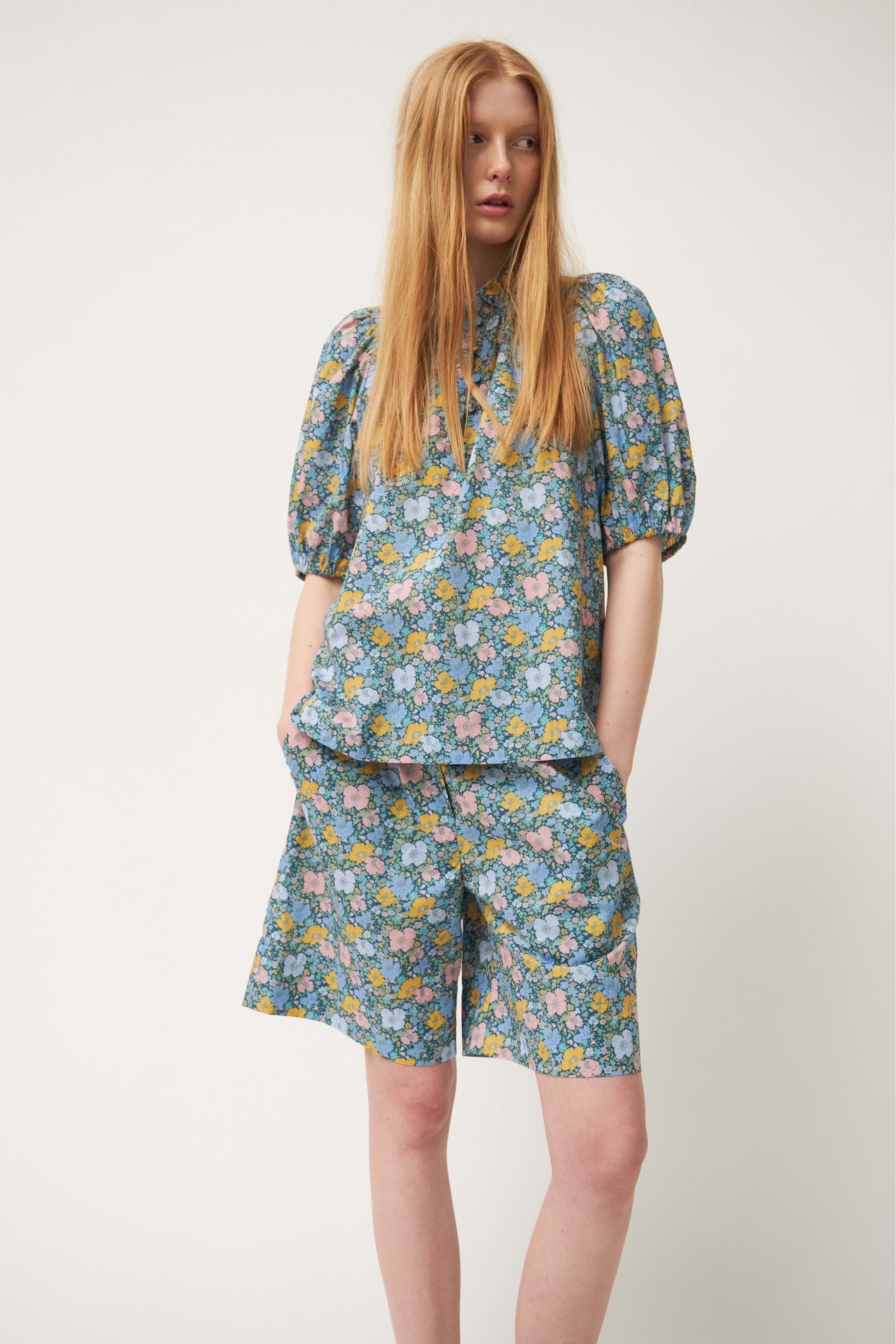 Woman in blouse and shorts with green flower pattern
