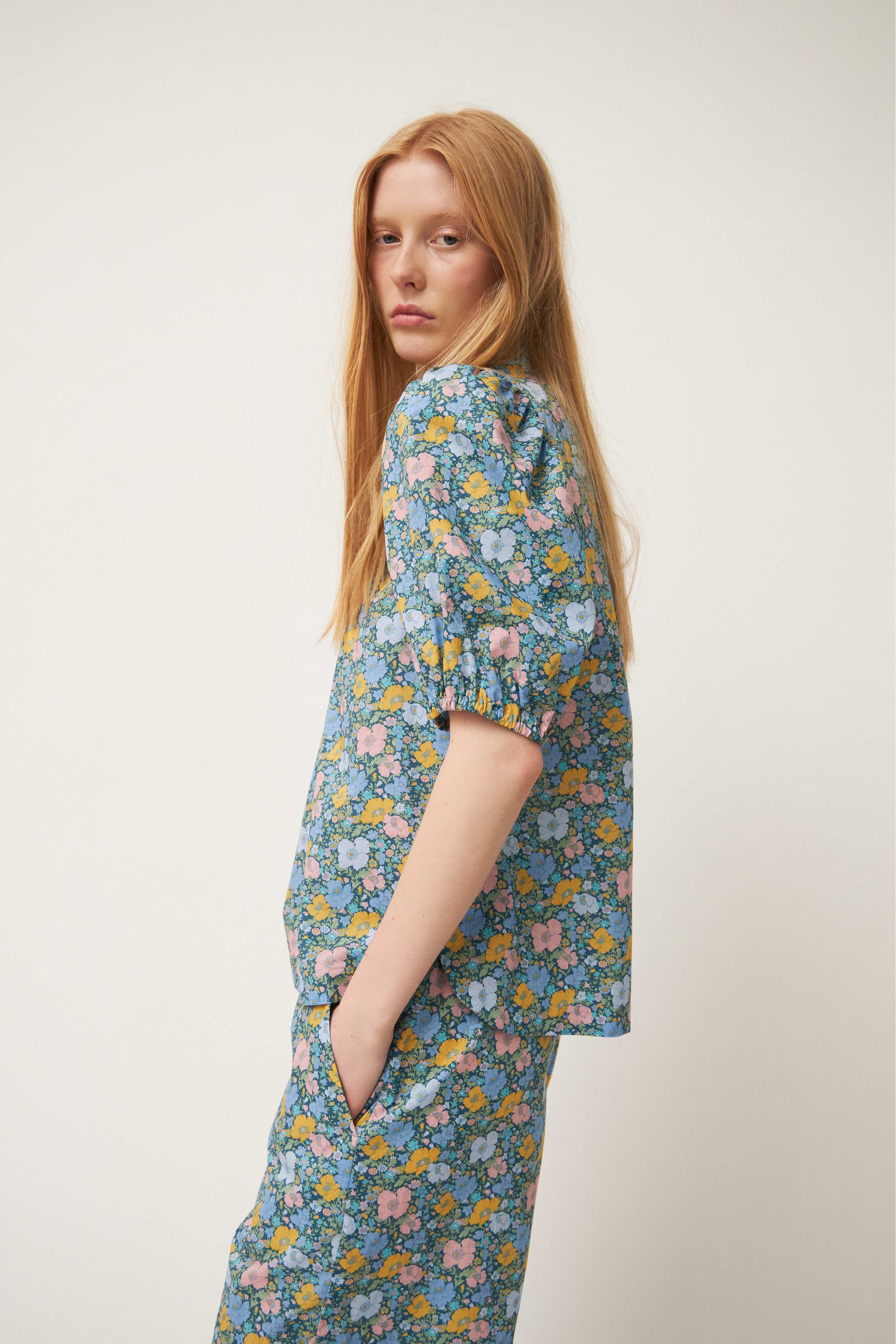 Woman in blouse and shorts with green flower pattern