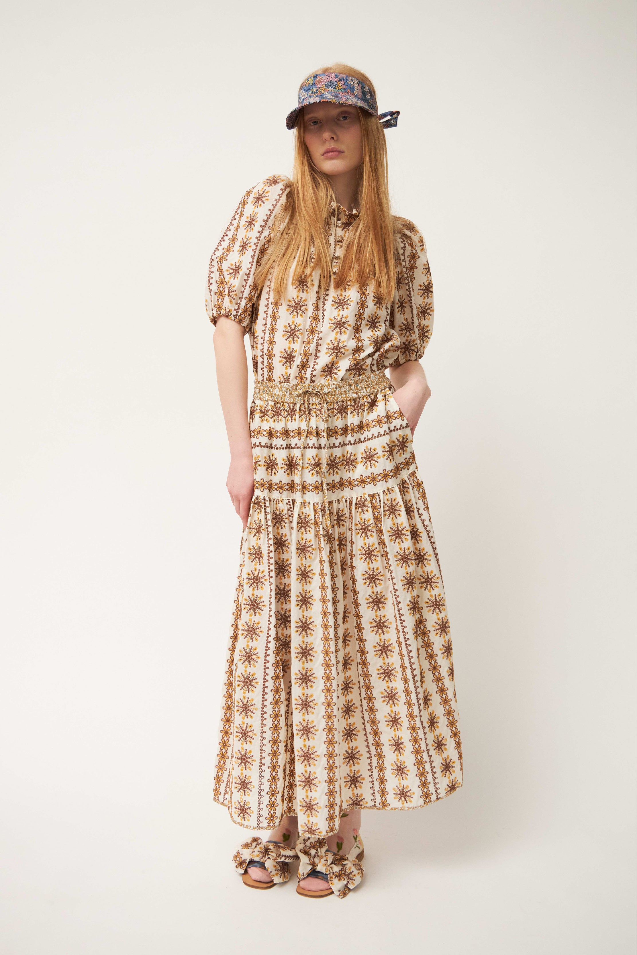 Woman in brown patterned blouse and skirt