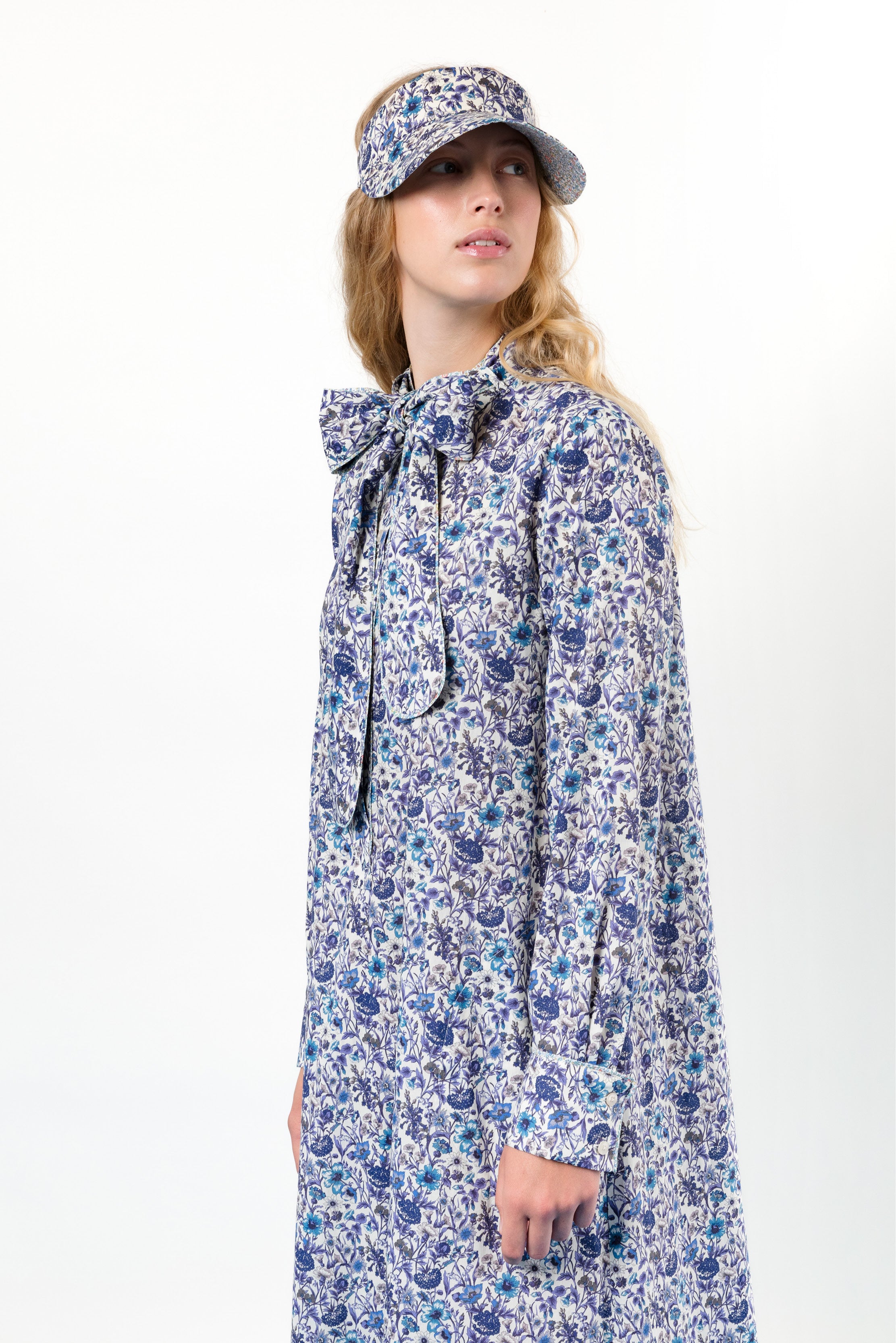 Woman in dress with blue flower pattern and hat