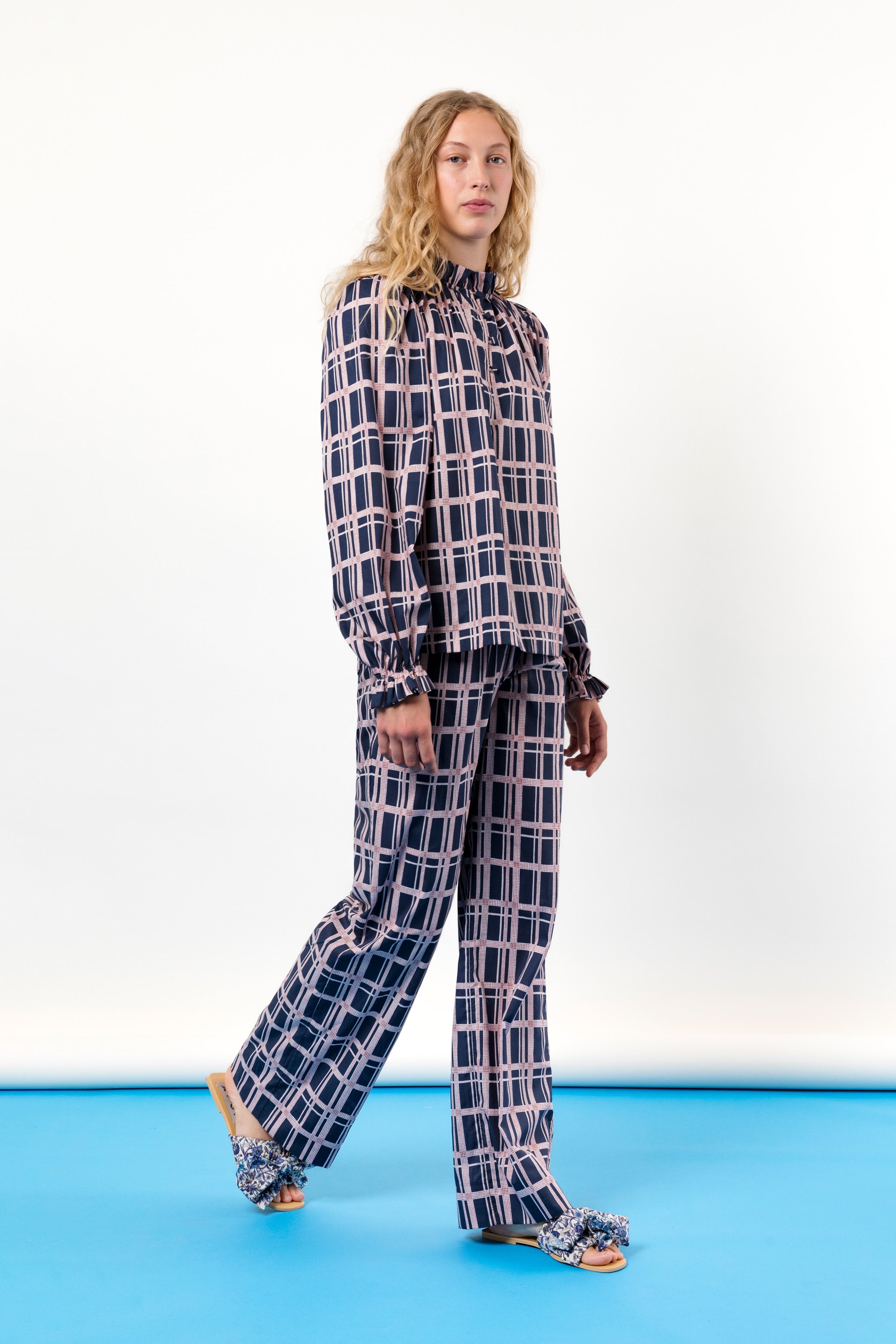 Woman in checked long sleeved shirt and trousers