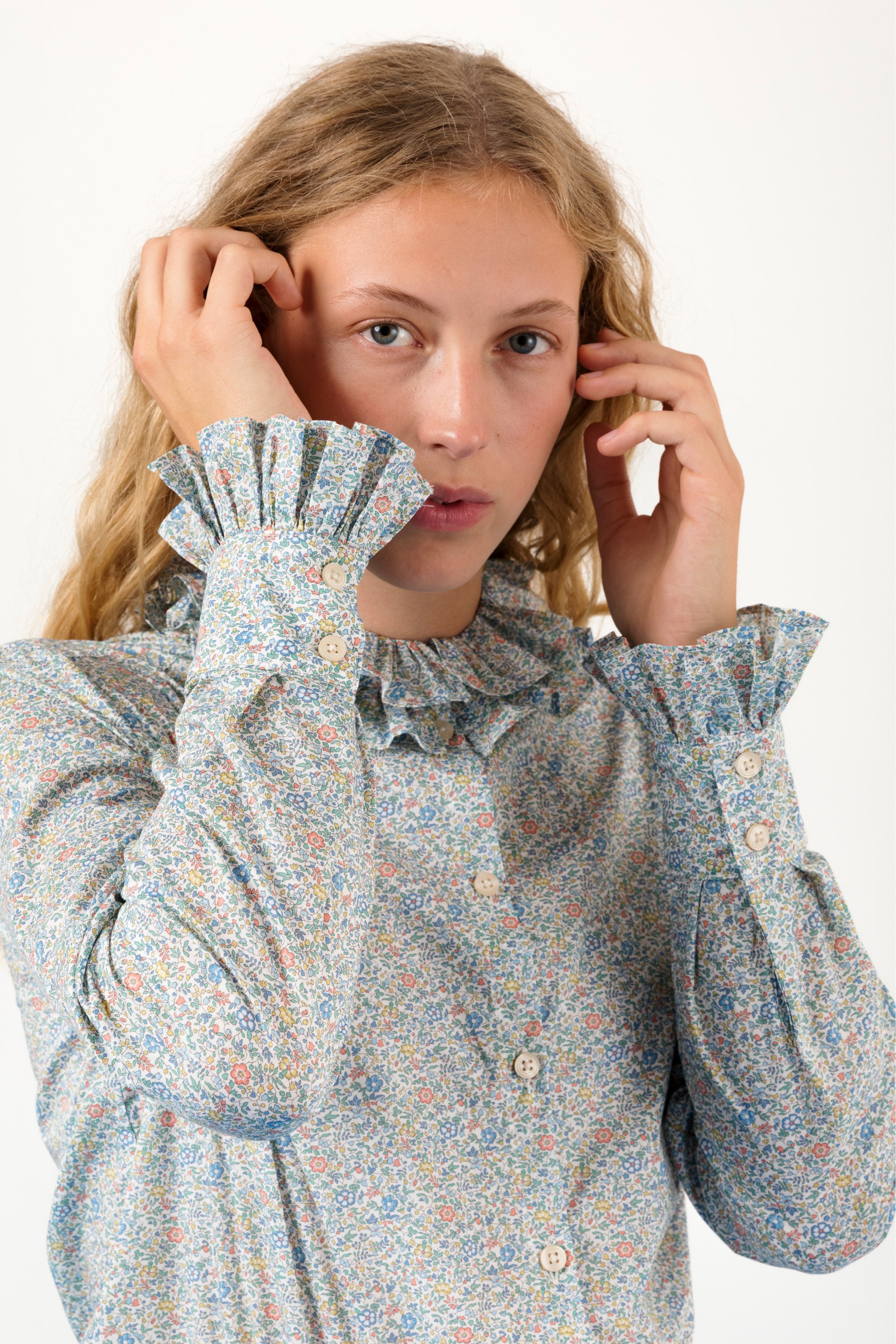 Woman in long sleeved green blouse with flowers and frills