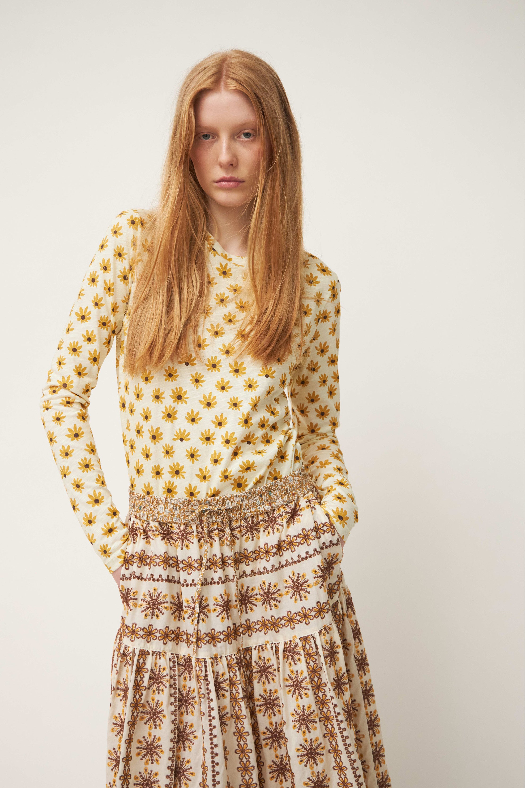 Woman in sunflower t-shirt and maxi skirt with laced beige and white pattern