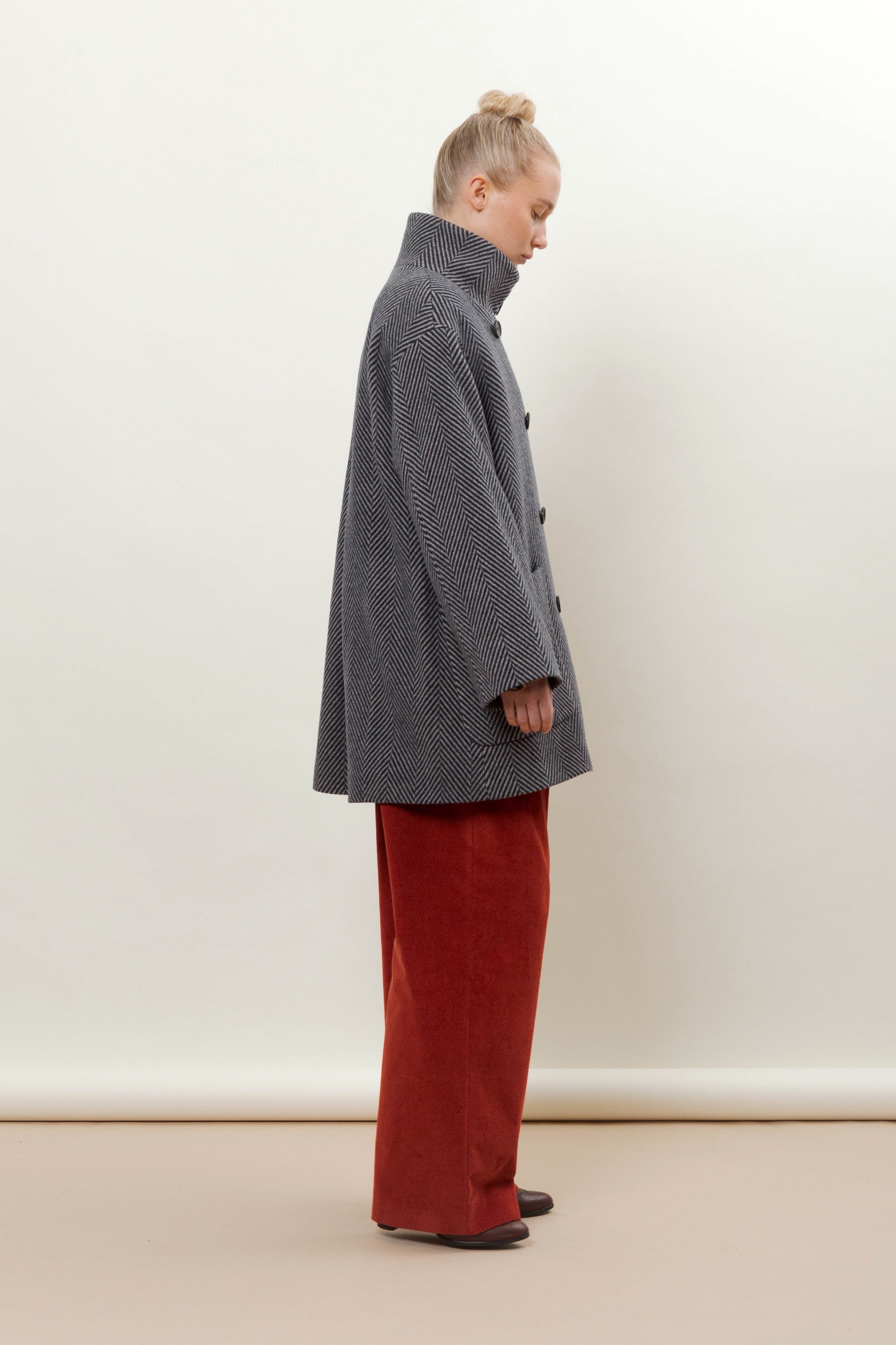 Woman in blue wool jacket with stand collar and red pants