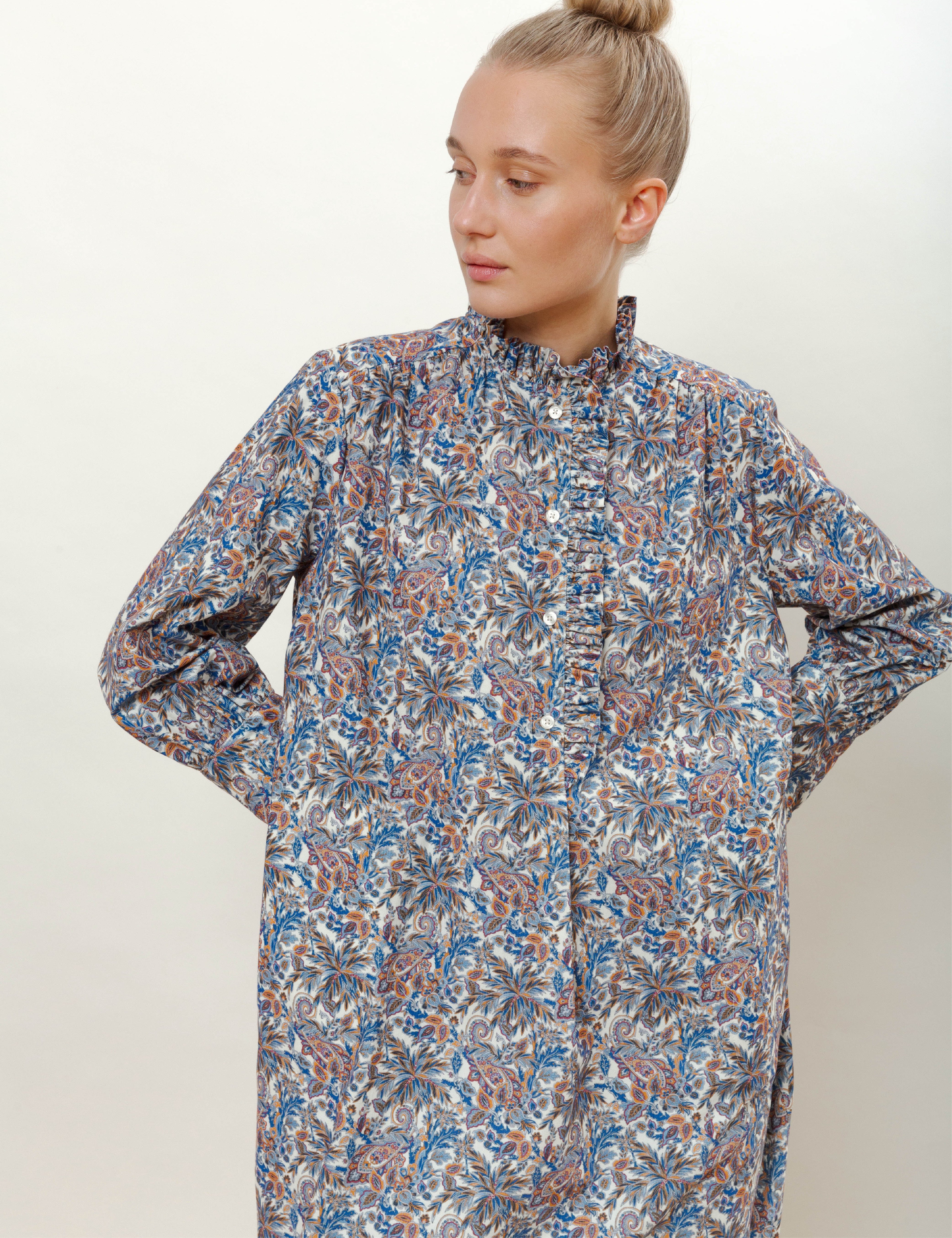 Woman in long-sleeved floral print dress with ruffled stand collar
