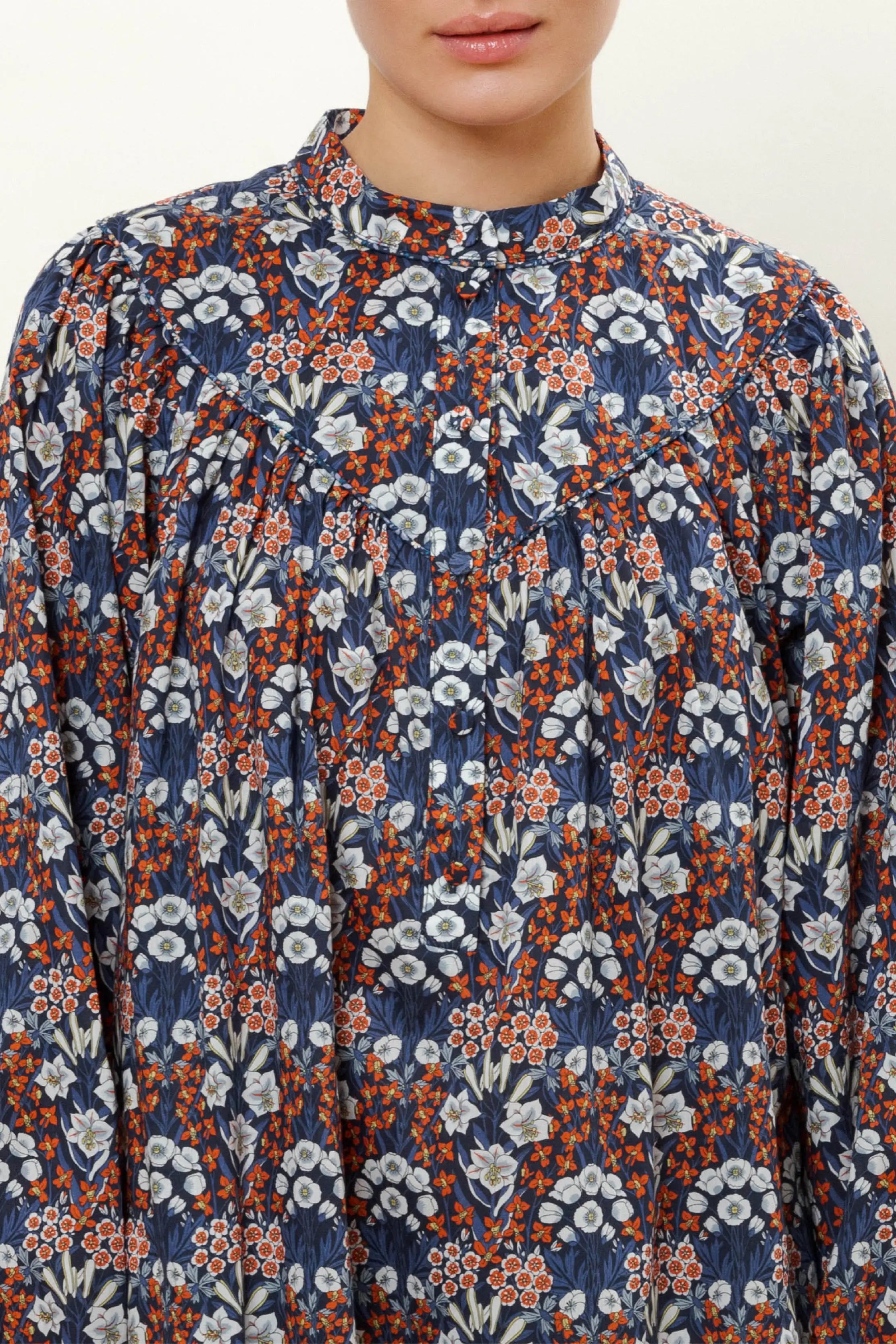 Woman in long sleeve cotton dress with blue red and white flower pattern