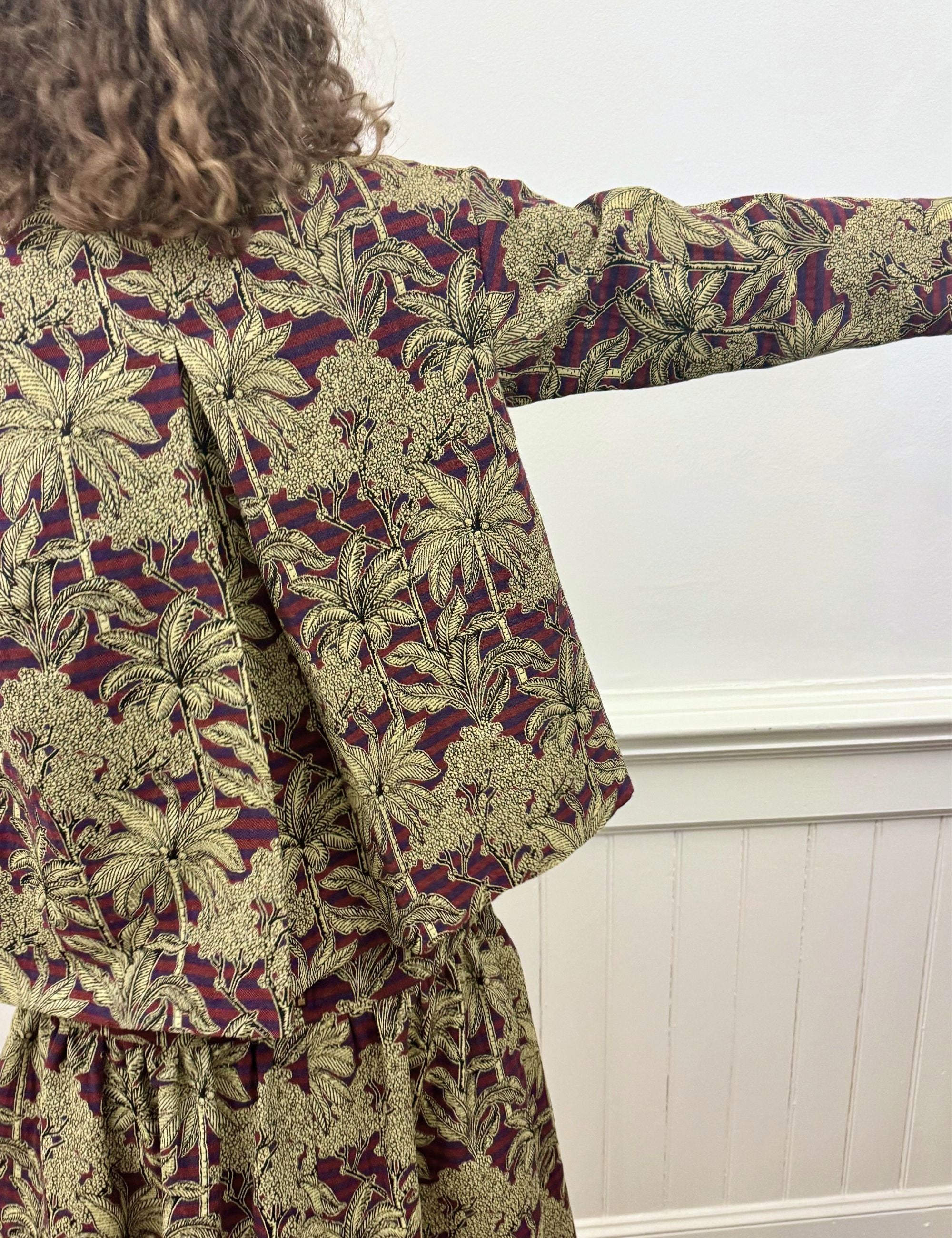 Woman in palm print jacket and skirt