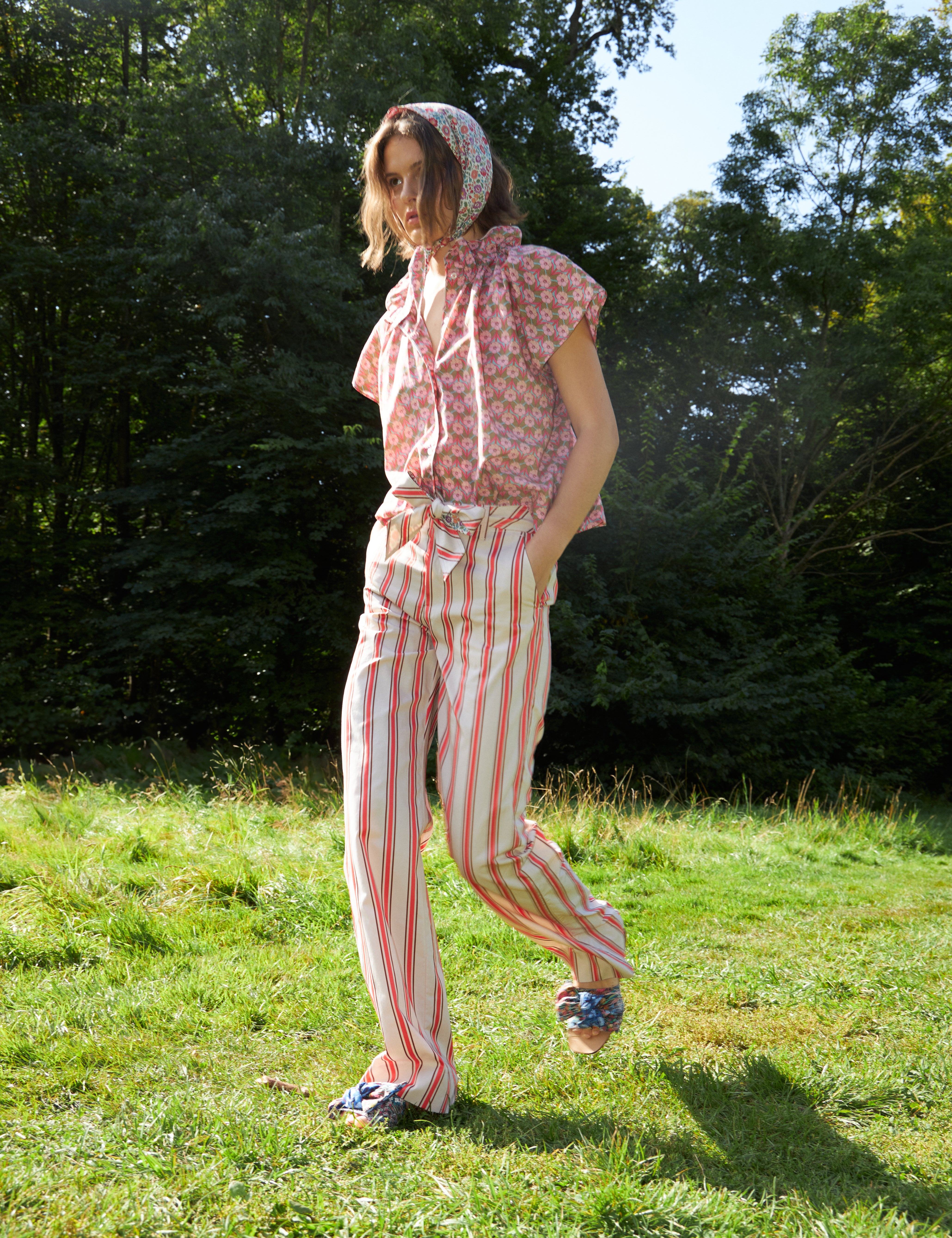 Woman in red and white striped pants with cotton belt and short sleeved blouse with pink floral print