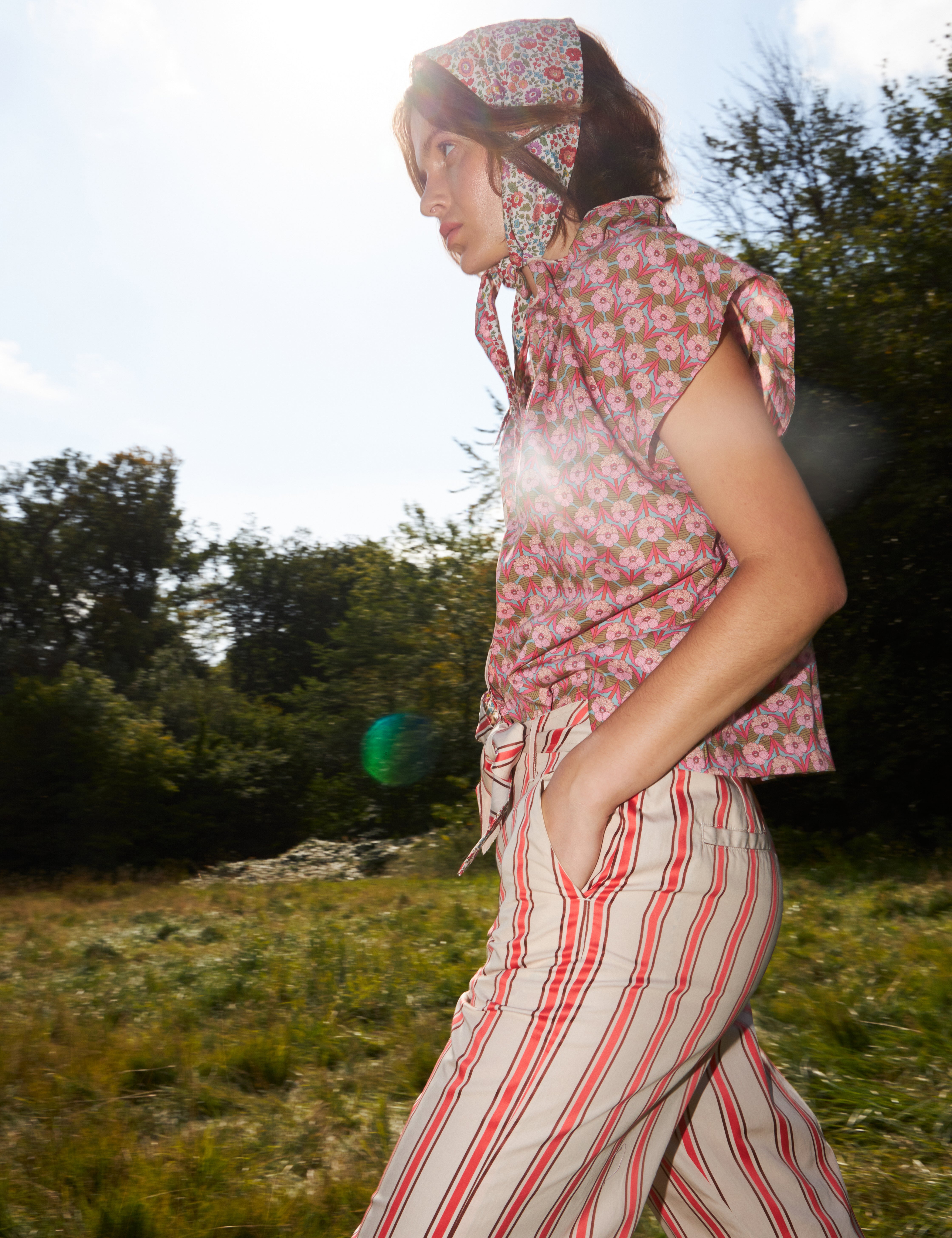 Woman in red and white striped pants with cotton belt and short sleeved blouse with pink floral print