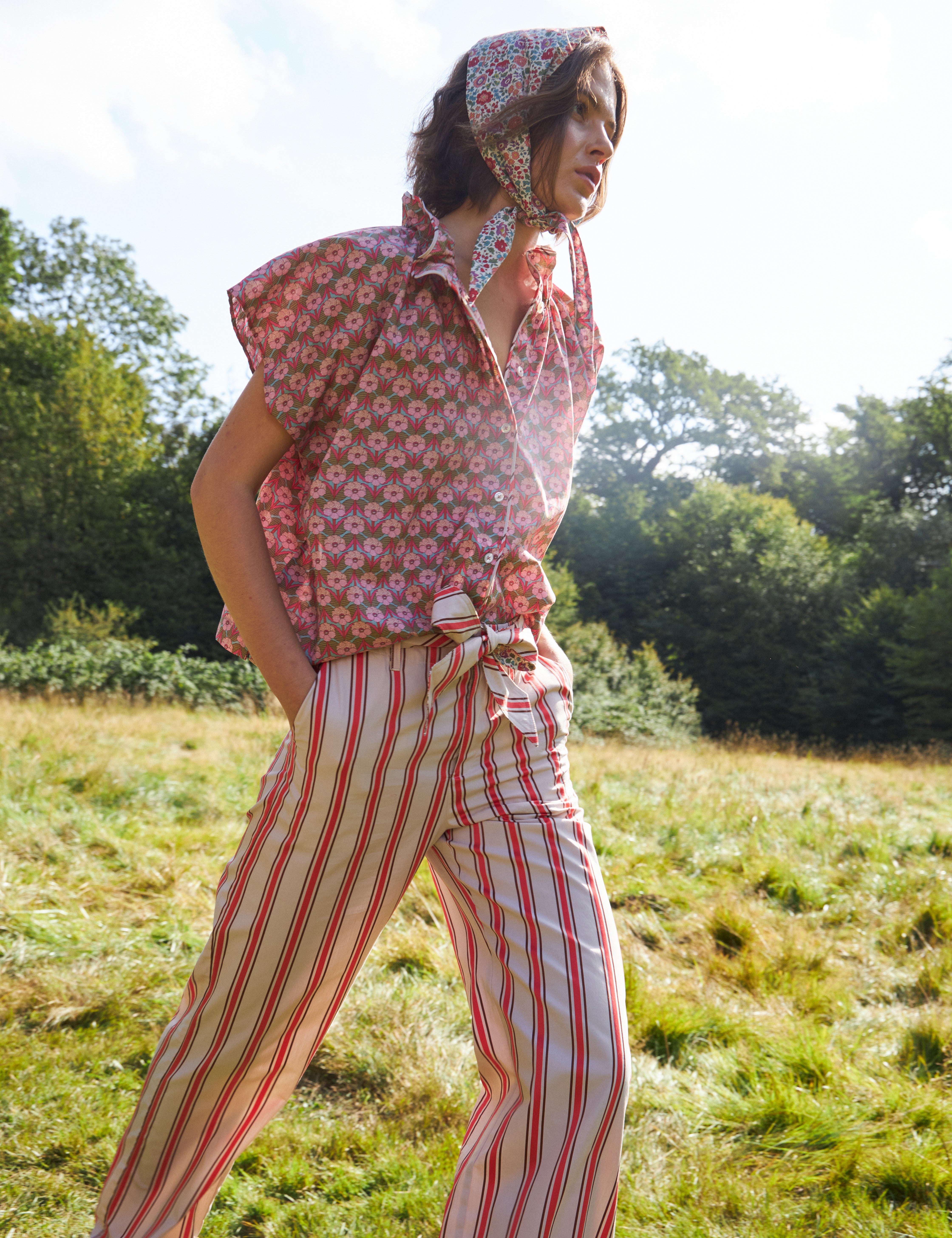 Woman in red and white striped pants with cotton belt and short sleeved blouse with pink floral print