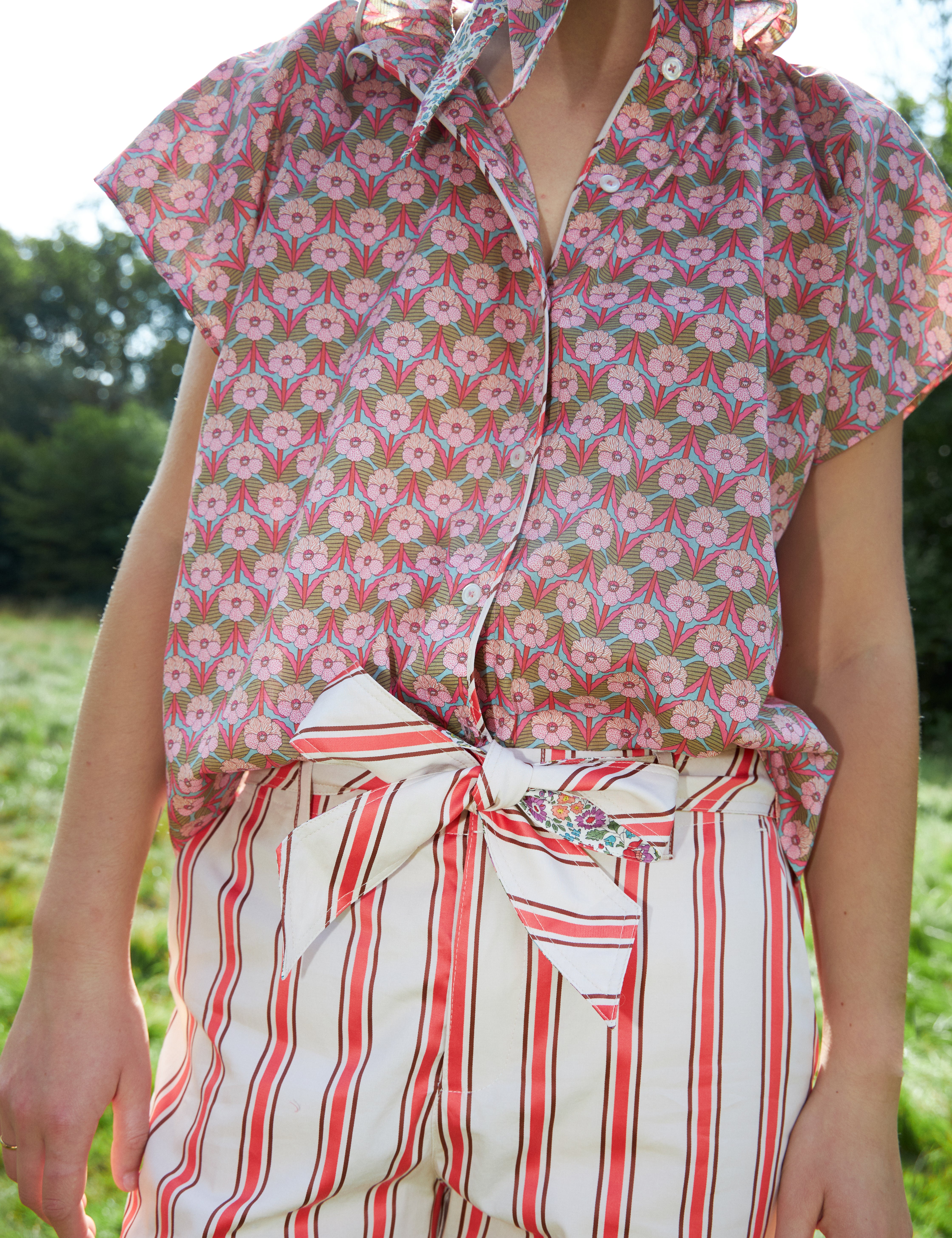 Woman in red and white striped pants with cotton belt and short sleeved blouse with pink floral print