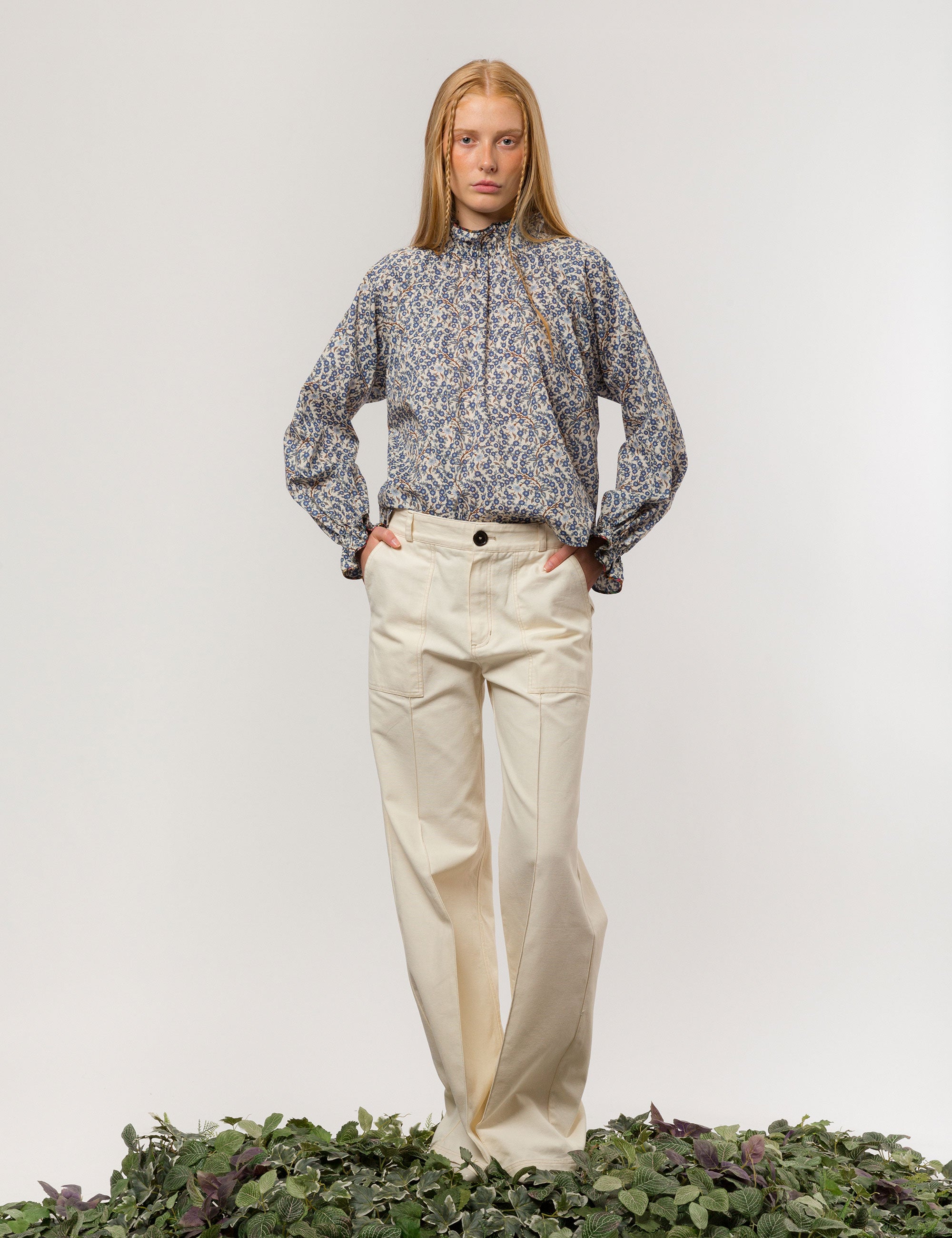 Woman in creme white wide canvas pants and blue and white long-sleeved floral print shirt