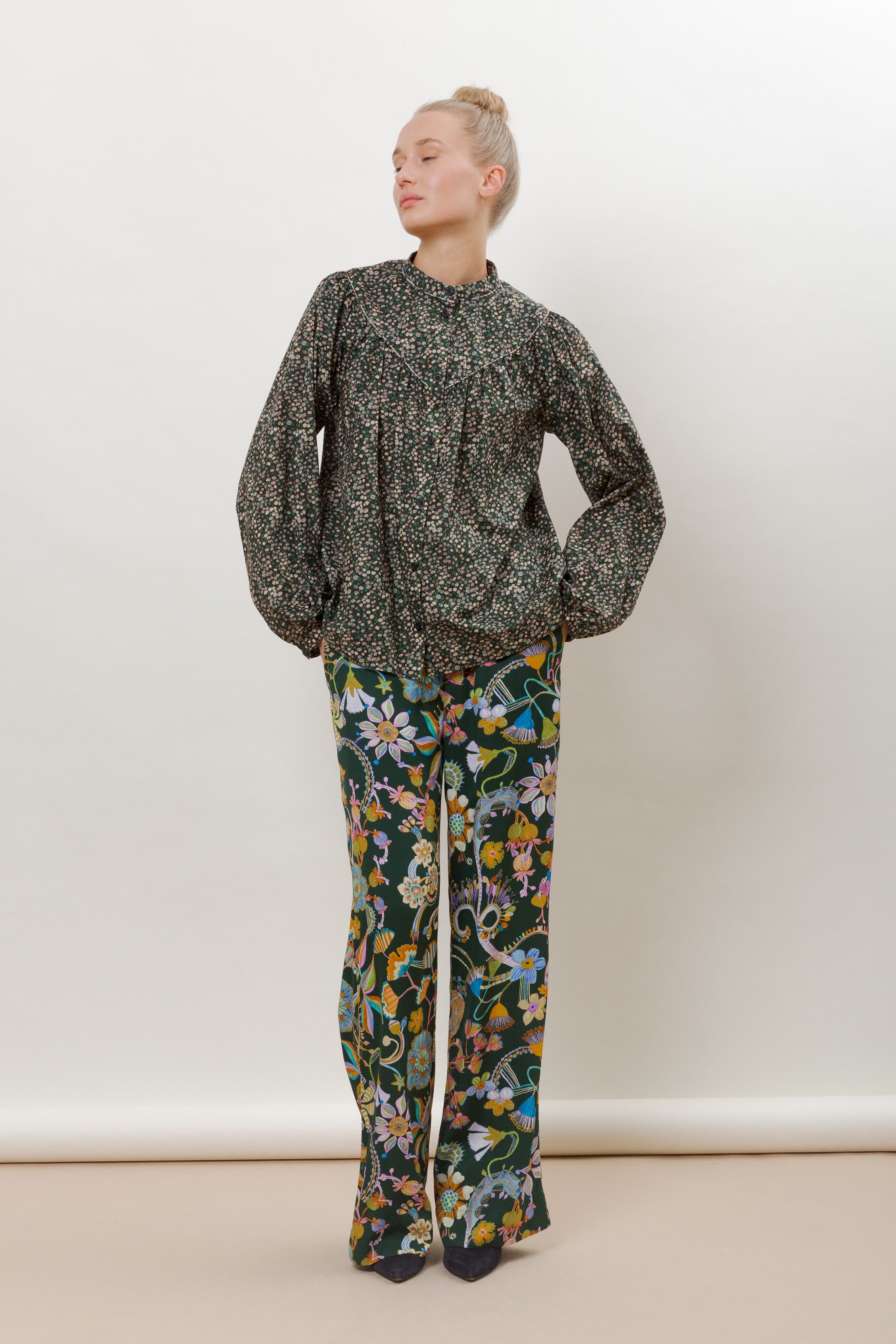 Woman in marguerite floral print blouse with long sleeves