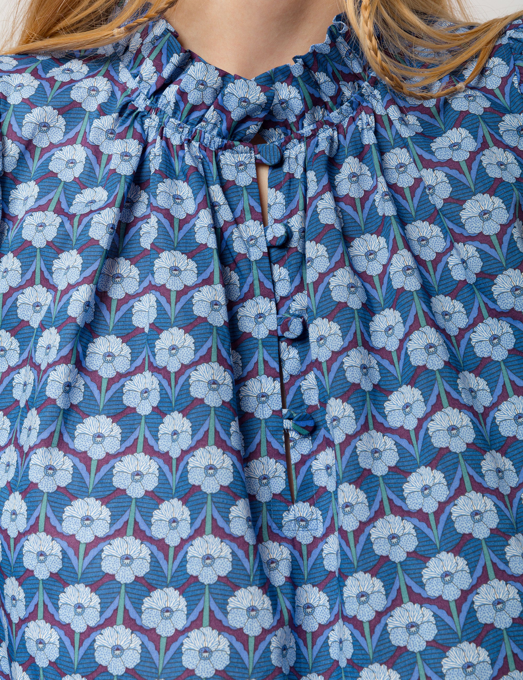 Woman in liberty cotton blue floral print shirt with frilled cuffs and collar