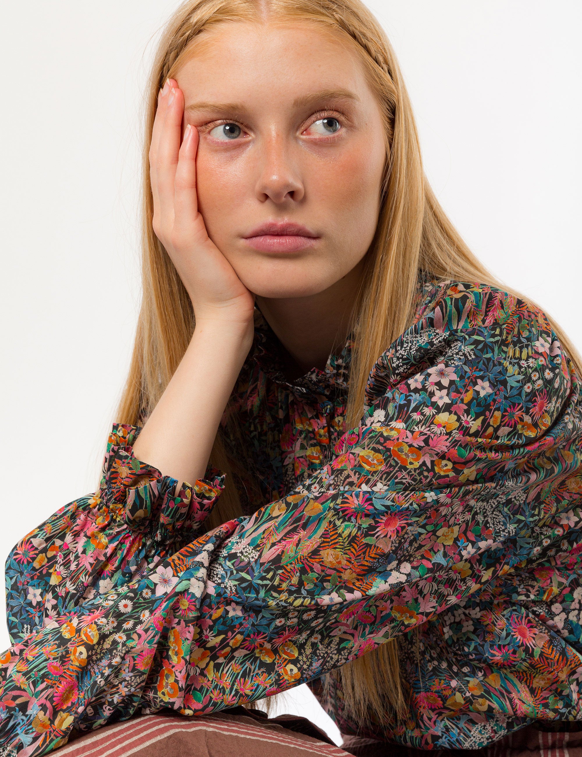 Woman in liberty cotton multi-colored floral print shirt with frilled cuffs and collar