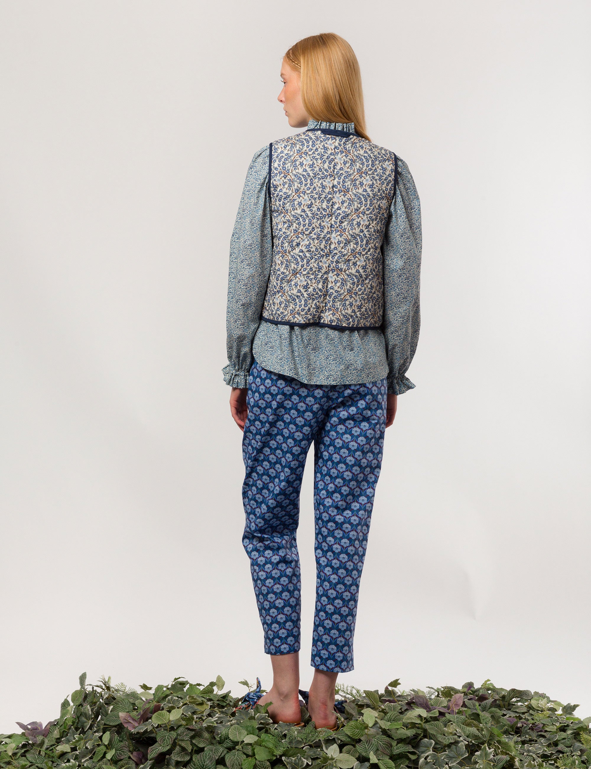 Woman in reversible liberty cotton blue and white floral print vest with buttons, pockets and blue pipings, blue floral shirt and blue floral print pants
