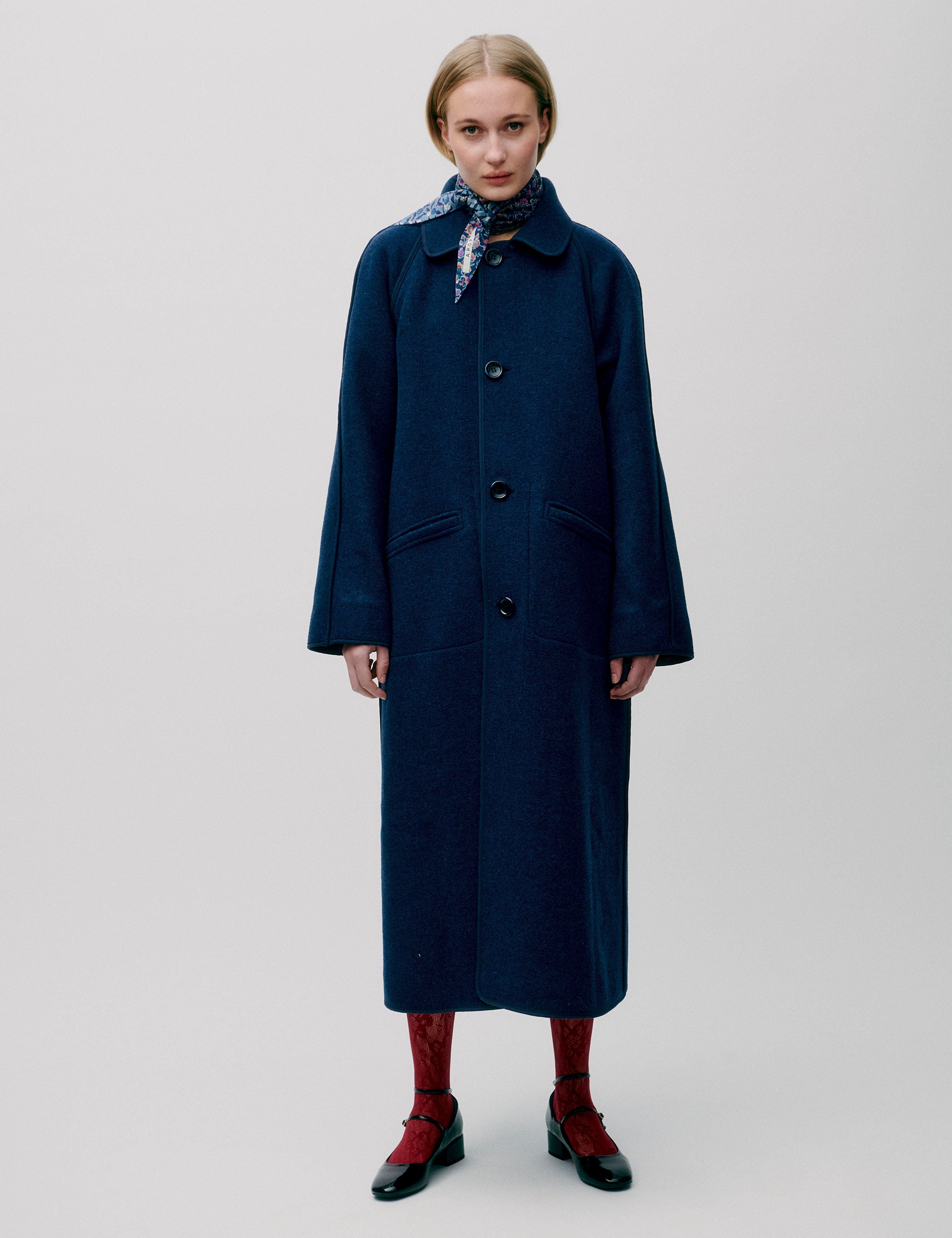 Woman in long blue wool coat with large buttons and collar