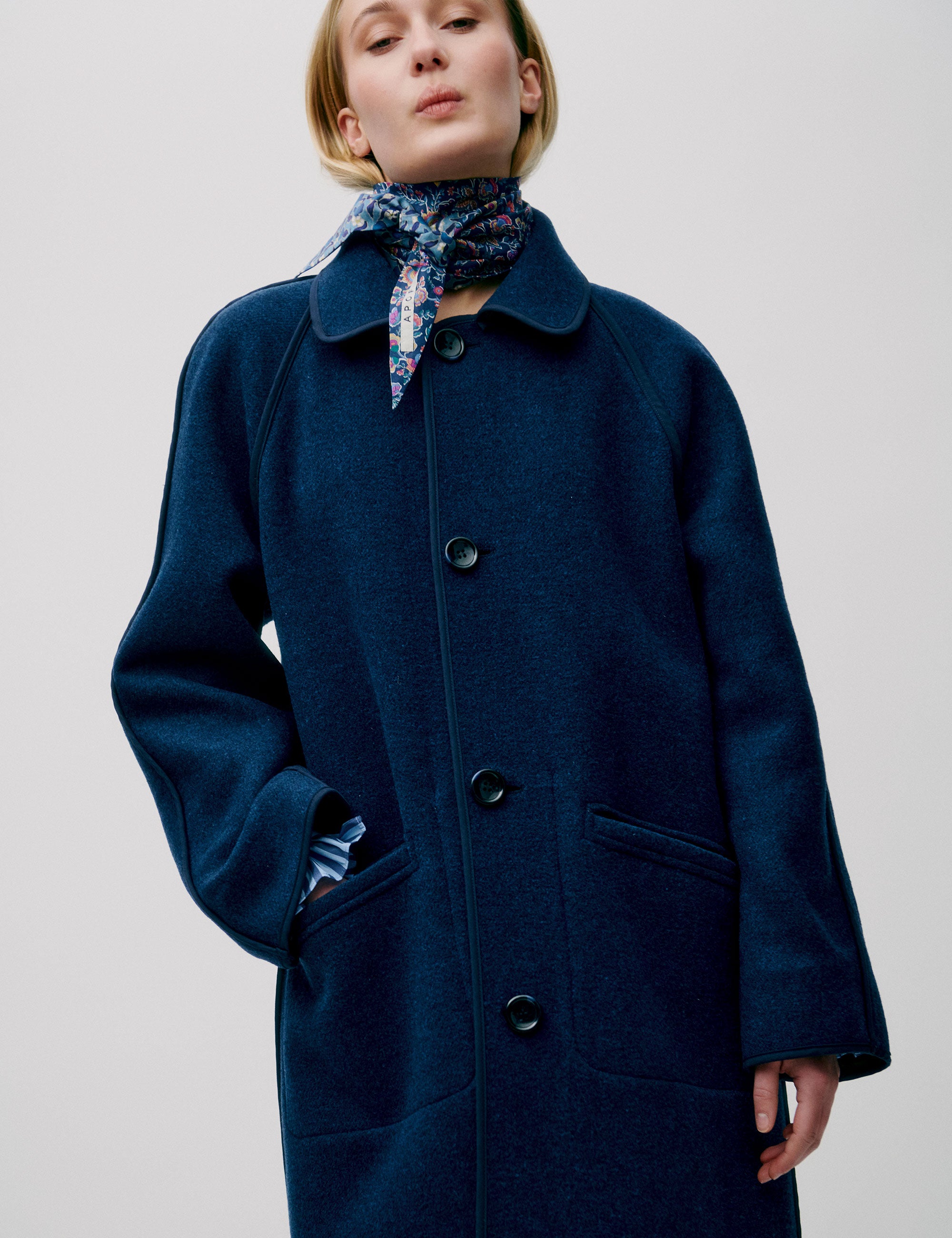 Woman in long blue wool coat with large buttons and collar