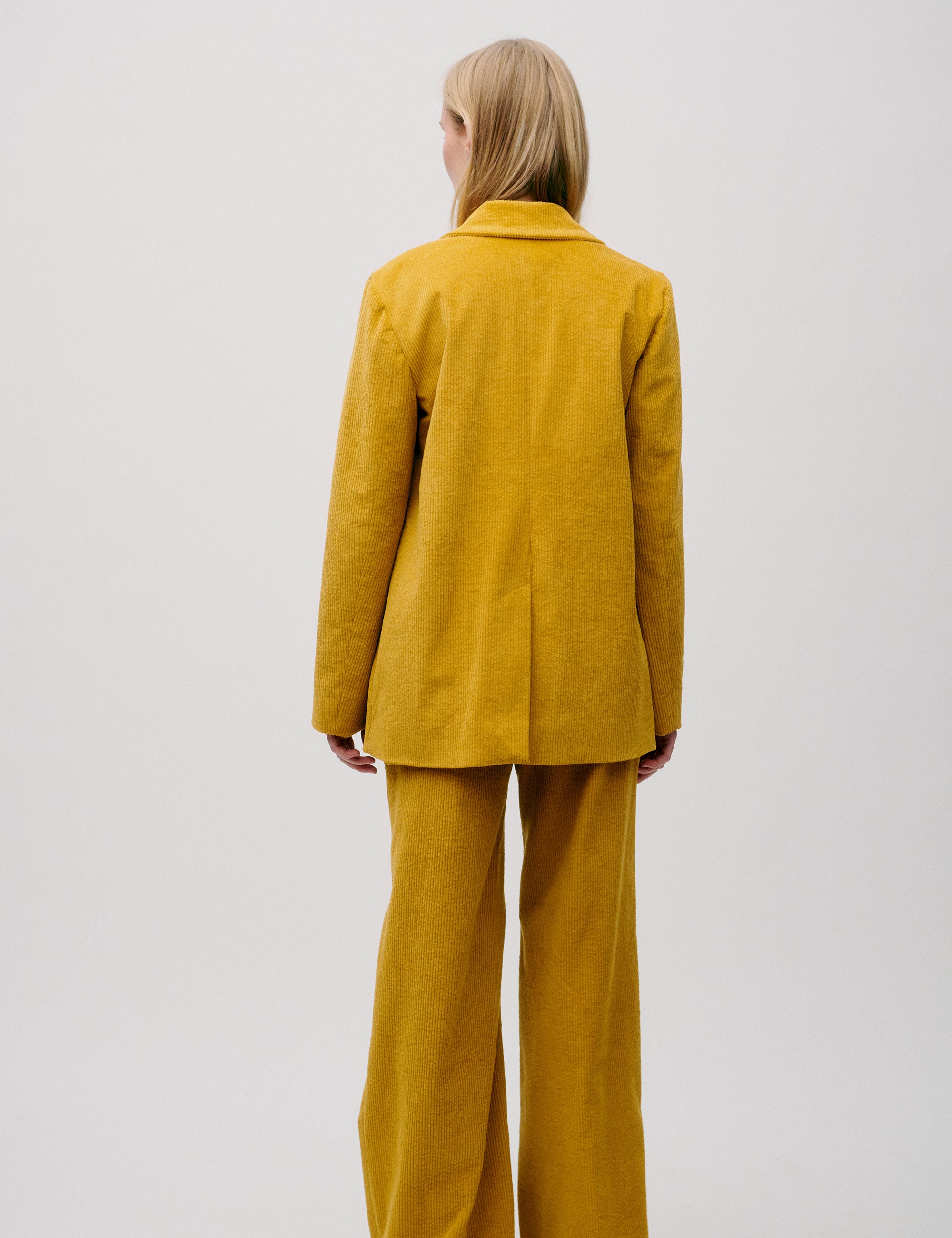 Back view of mustard yellow corduroy blazer and matching trousers