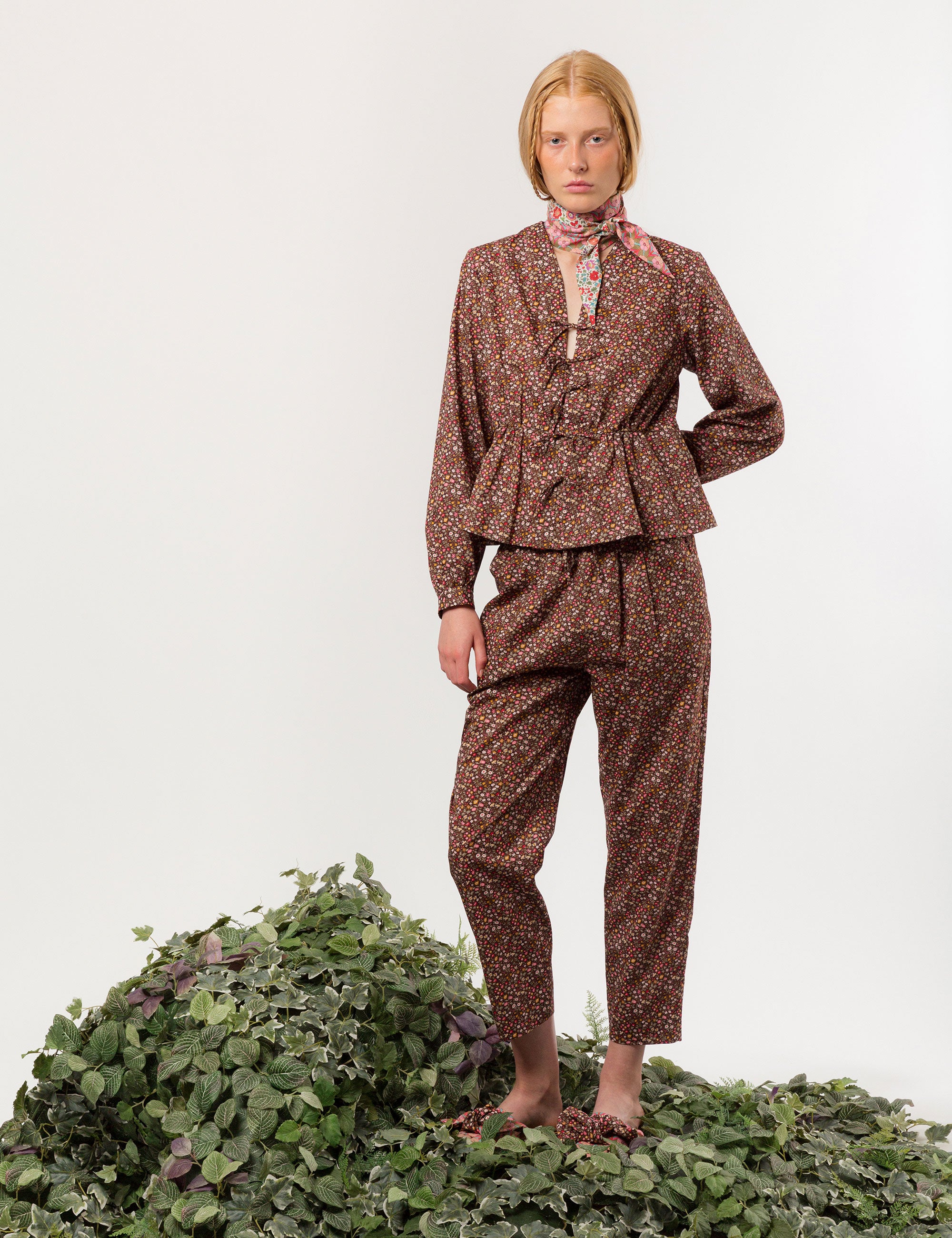 Woman in relaxed pants and matching long-sleeved v-neck shirt in liberty cotton brown and red small floral print