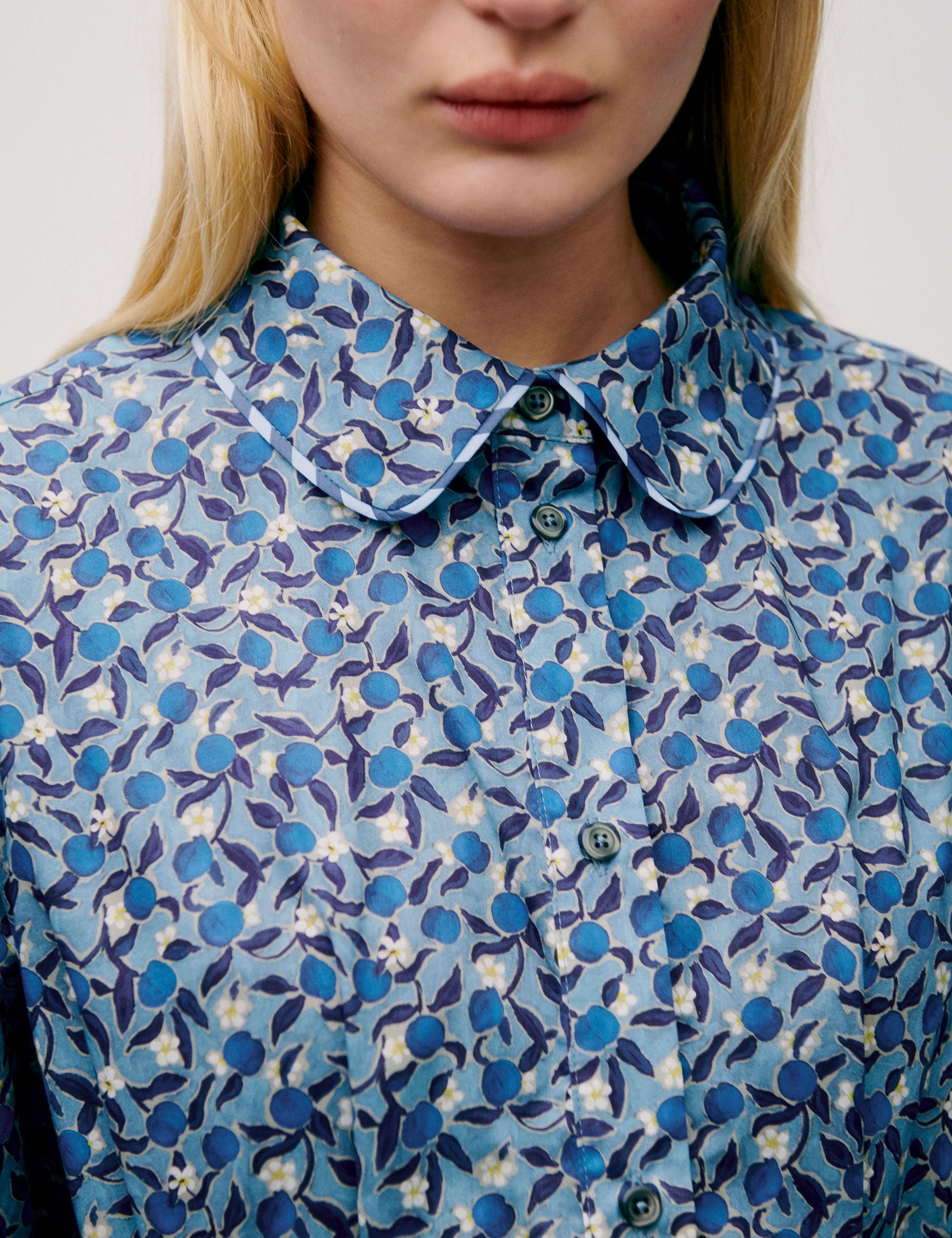 Woman in long blue flower patterned dress with long sleeves