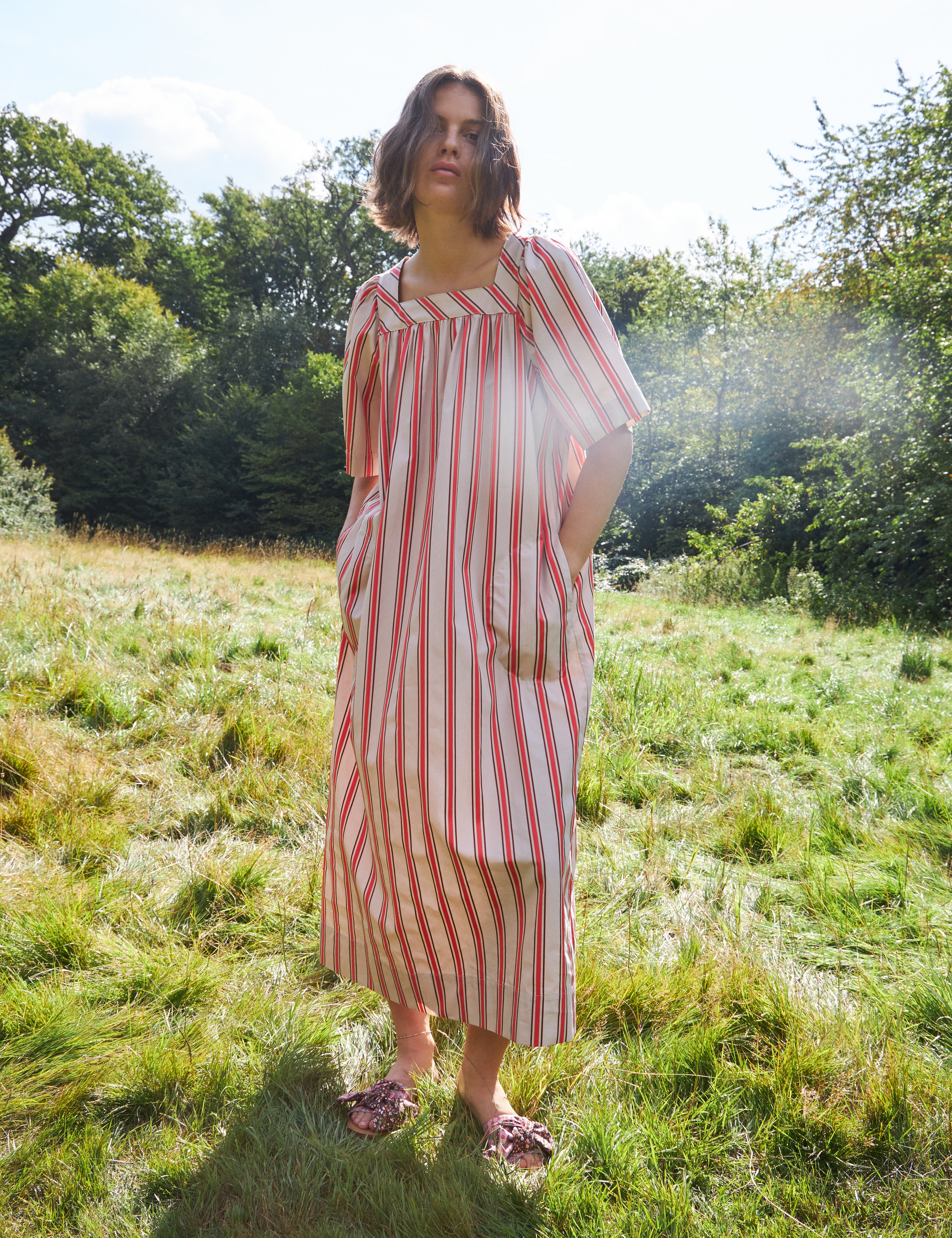 Woman in red and white striped summer dress with short sleeves and hidden pockets