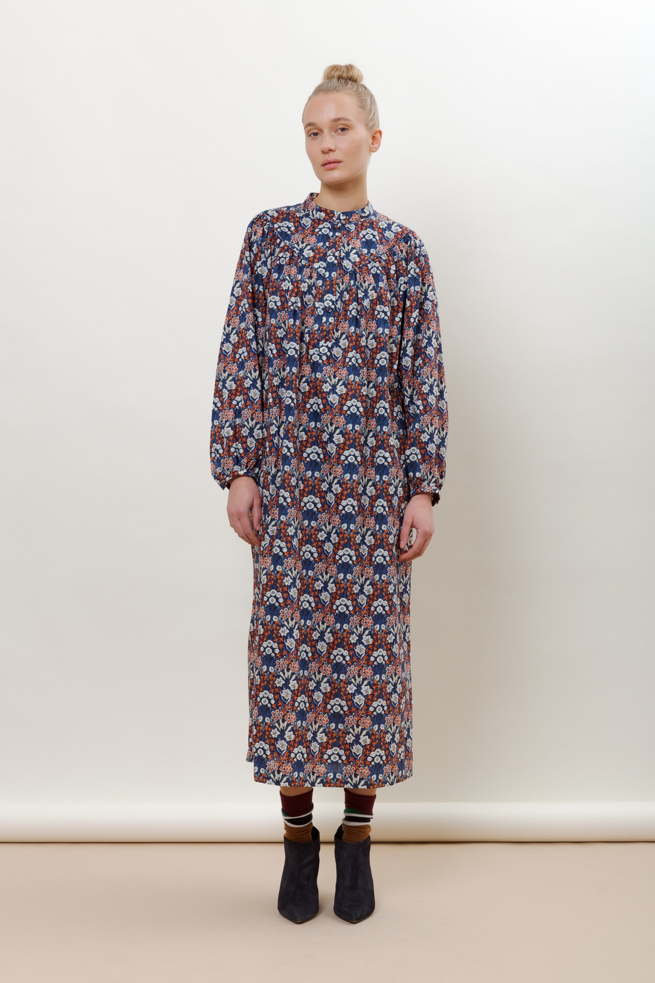 Woman in long sleeve cotton dress with blue red and white flower pattern