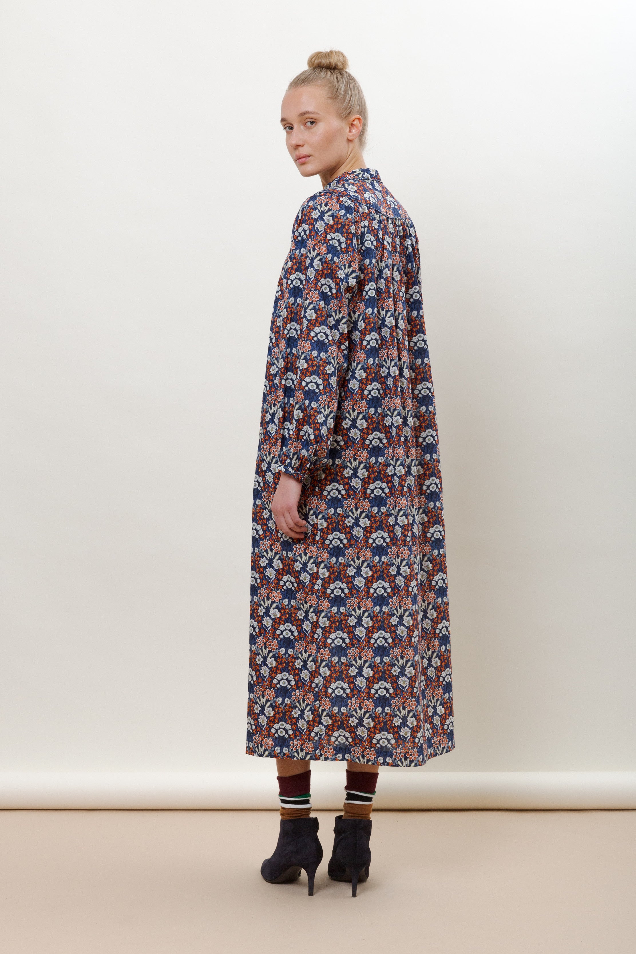 Woman in long sleeve cotton dress with blue red and white flower pattern