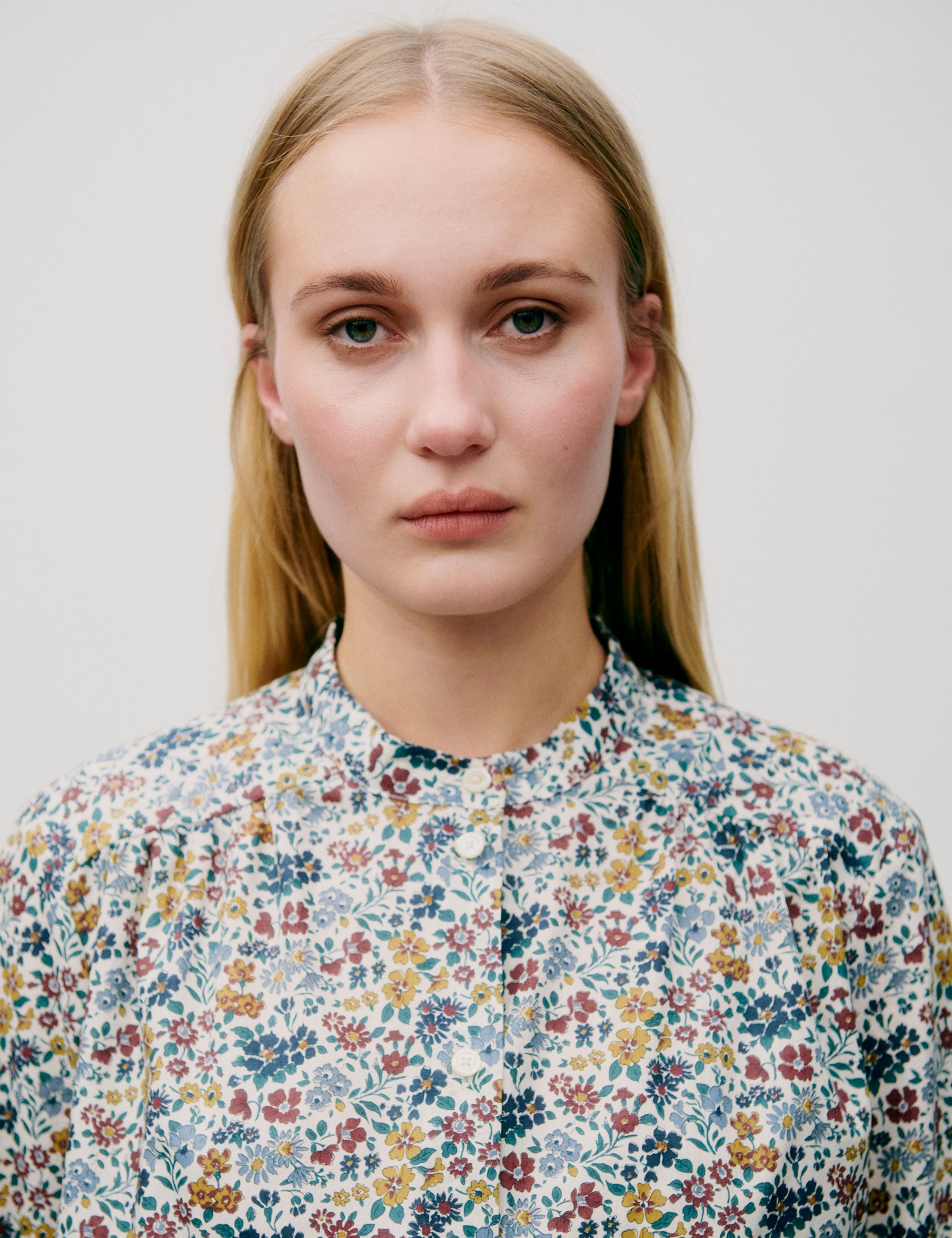 Woman in blue yellow and red floral patterned shirt with buttons