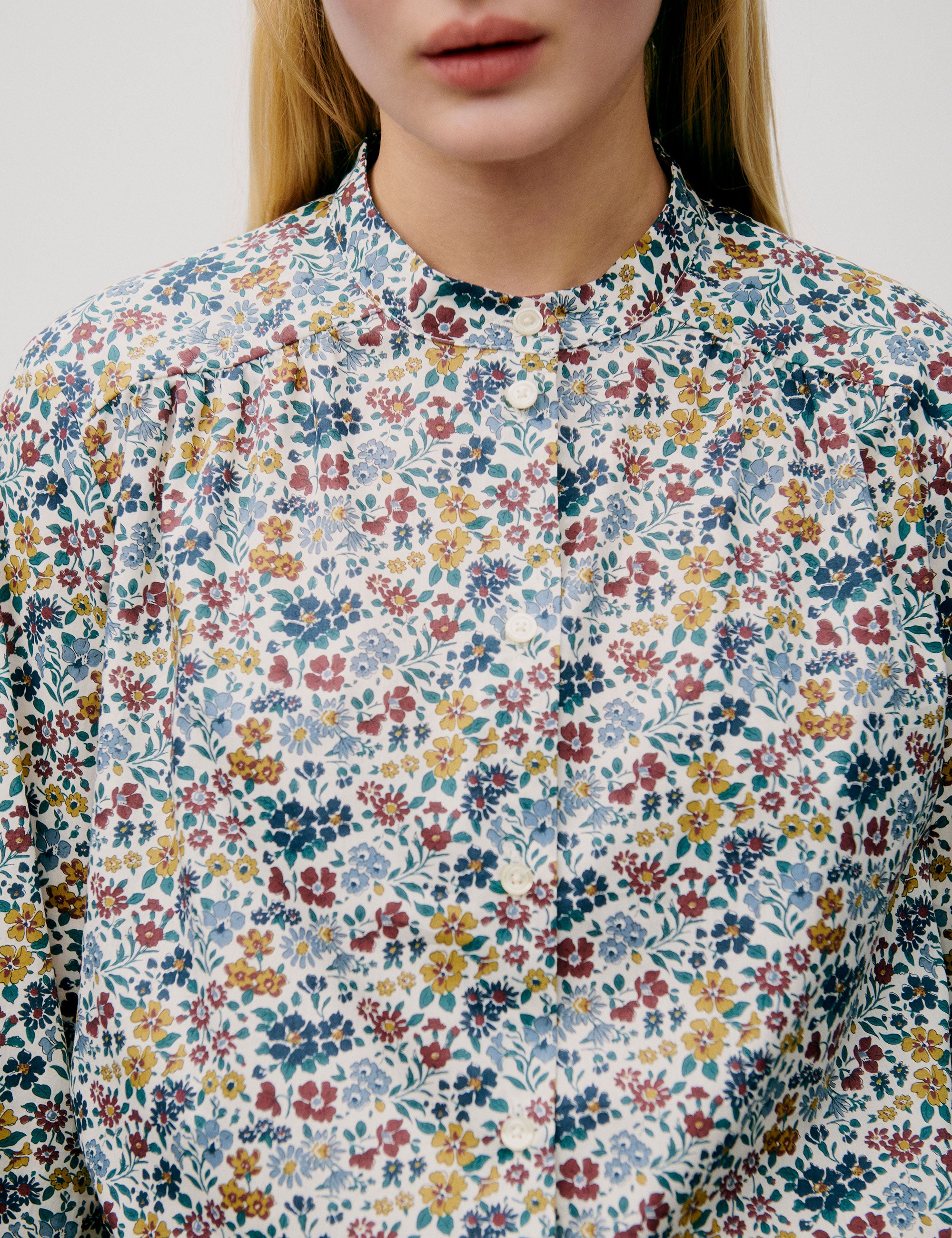 Woman in blue yellow and red floral patterned shirt with buttons