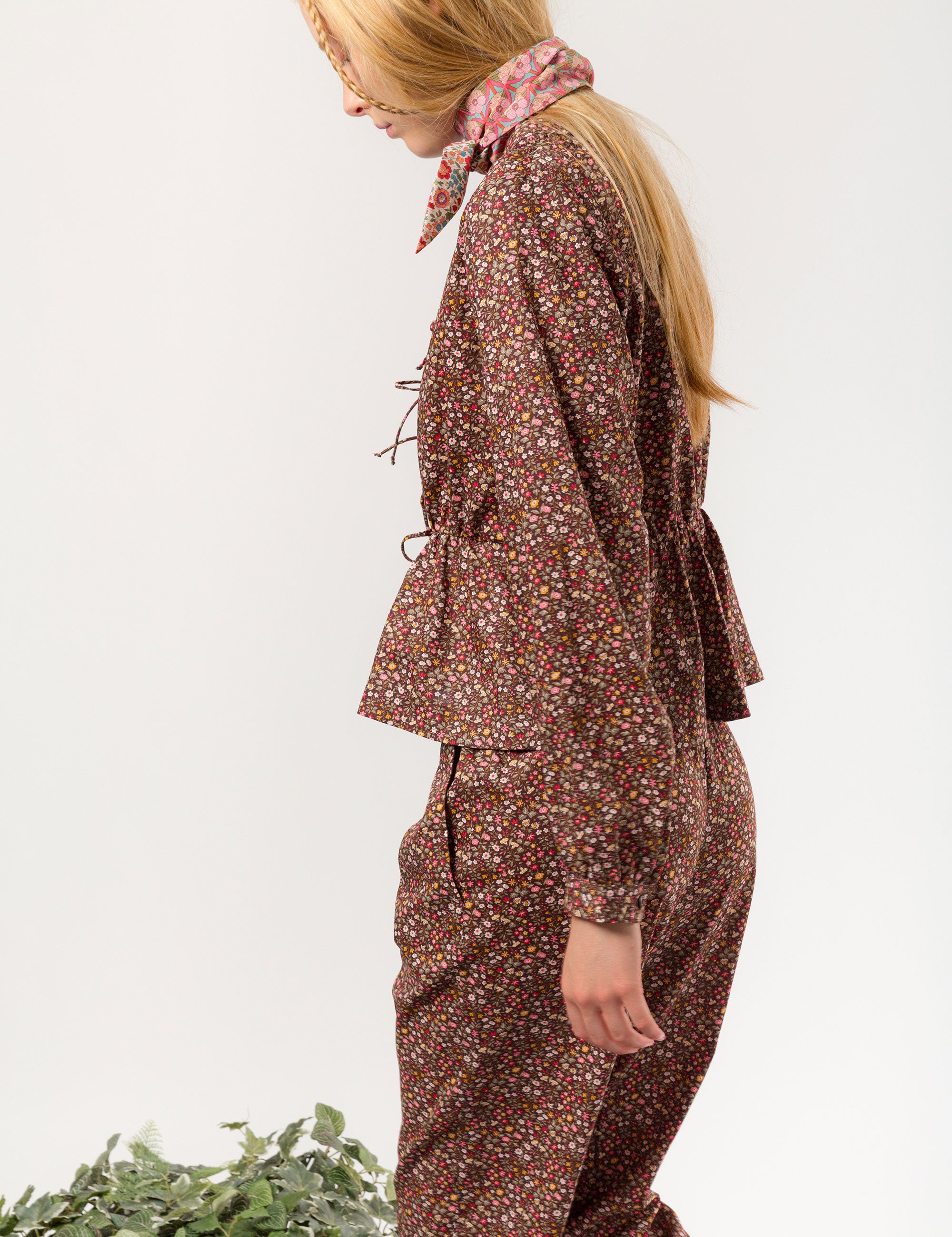 Woman in relaxed pants and matching long-sleeved v-neck shirt in liberty cotton brown and red small floral print