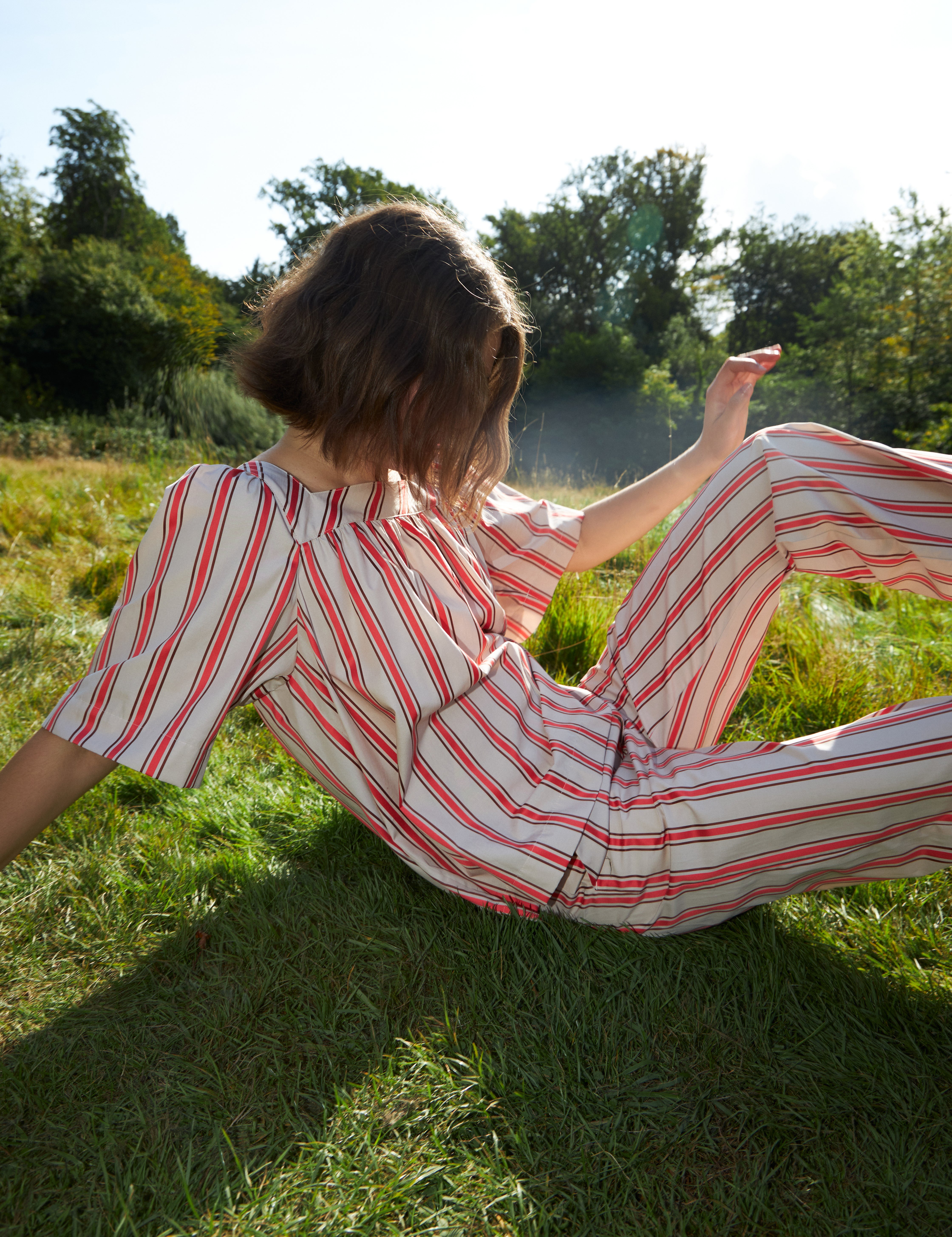 Woman in red and white striped pants and loose fit blouse with short sleeves