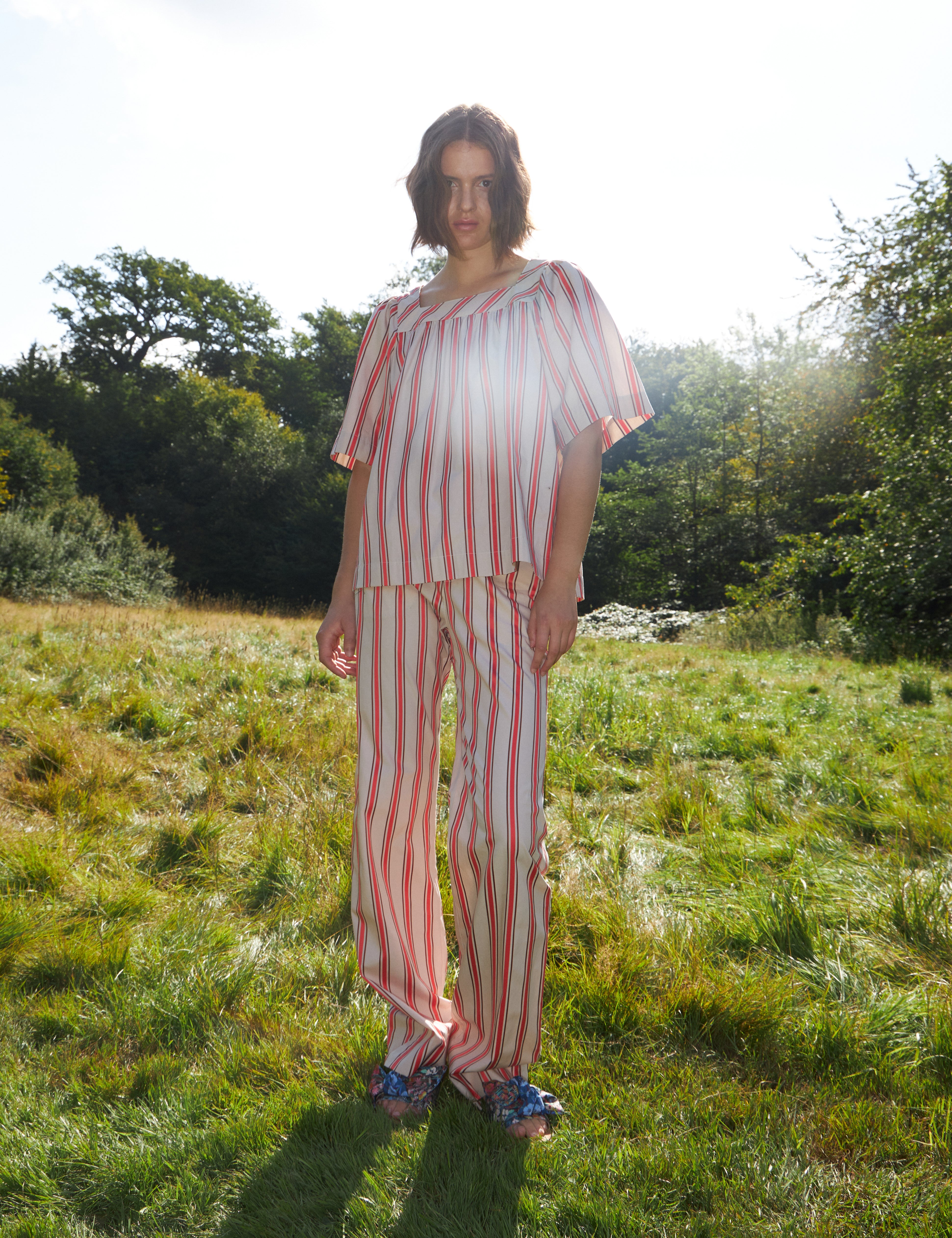 Woman in red and white striped pants and loose fit blouse with short sleeves