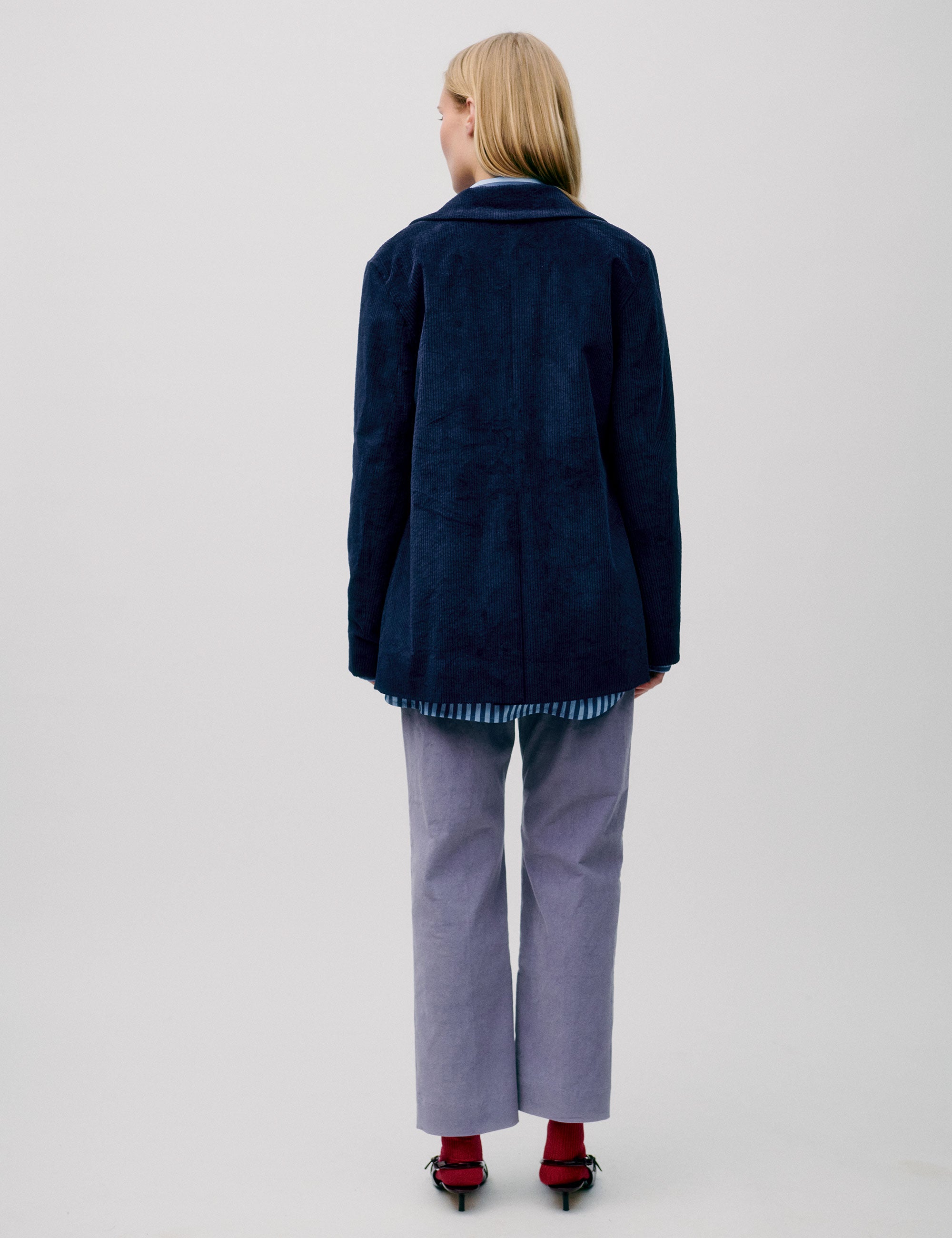 Woman wearing lavender straight-leg trousers with a striped shirt and navy corduroy blazer