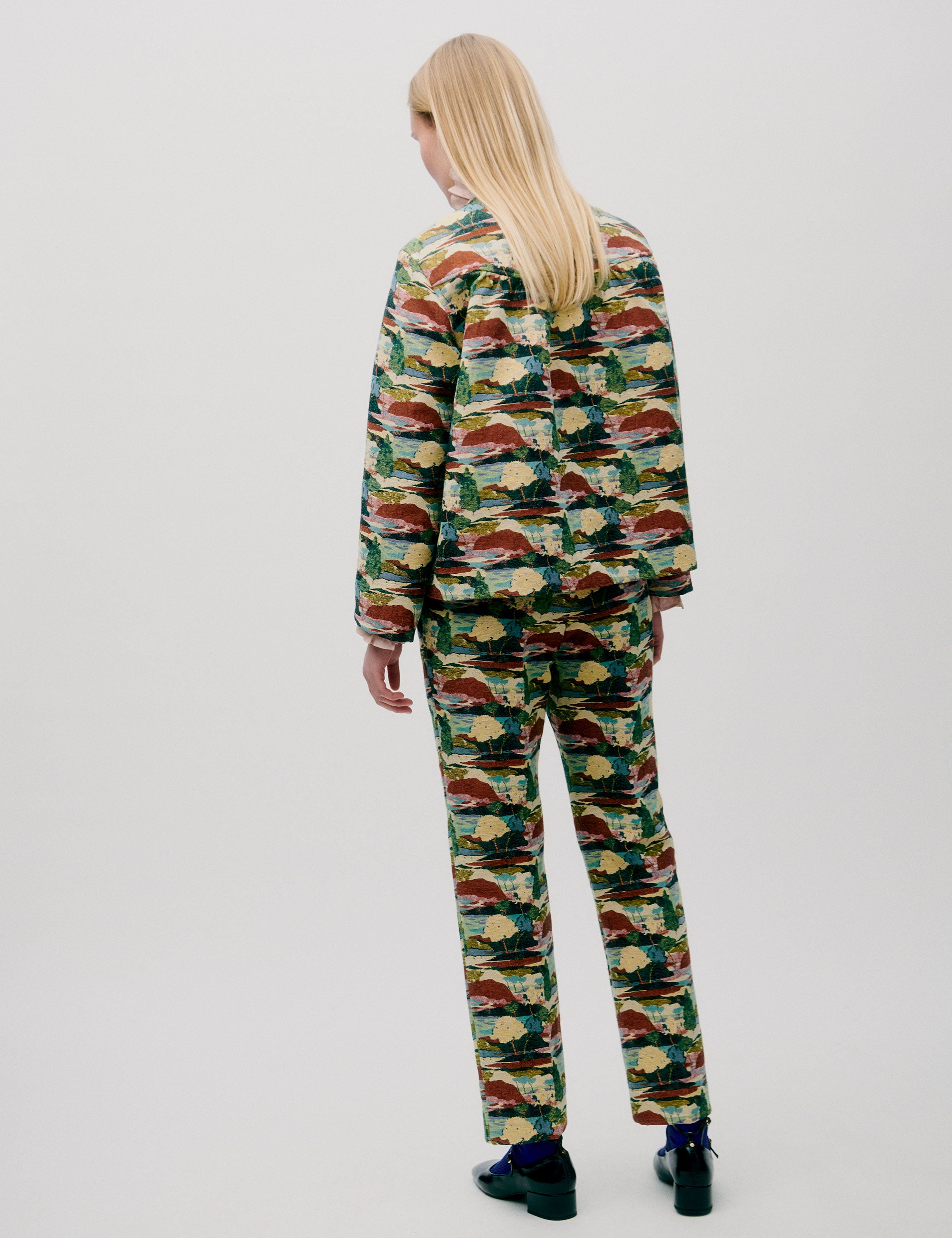 Woman in straight pants and jacket with artistic forest print