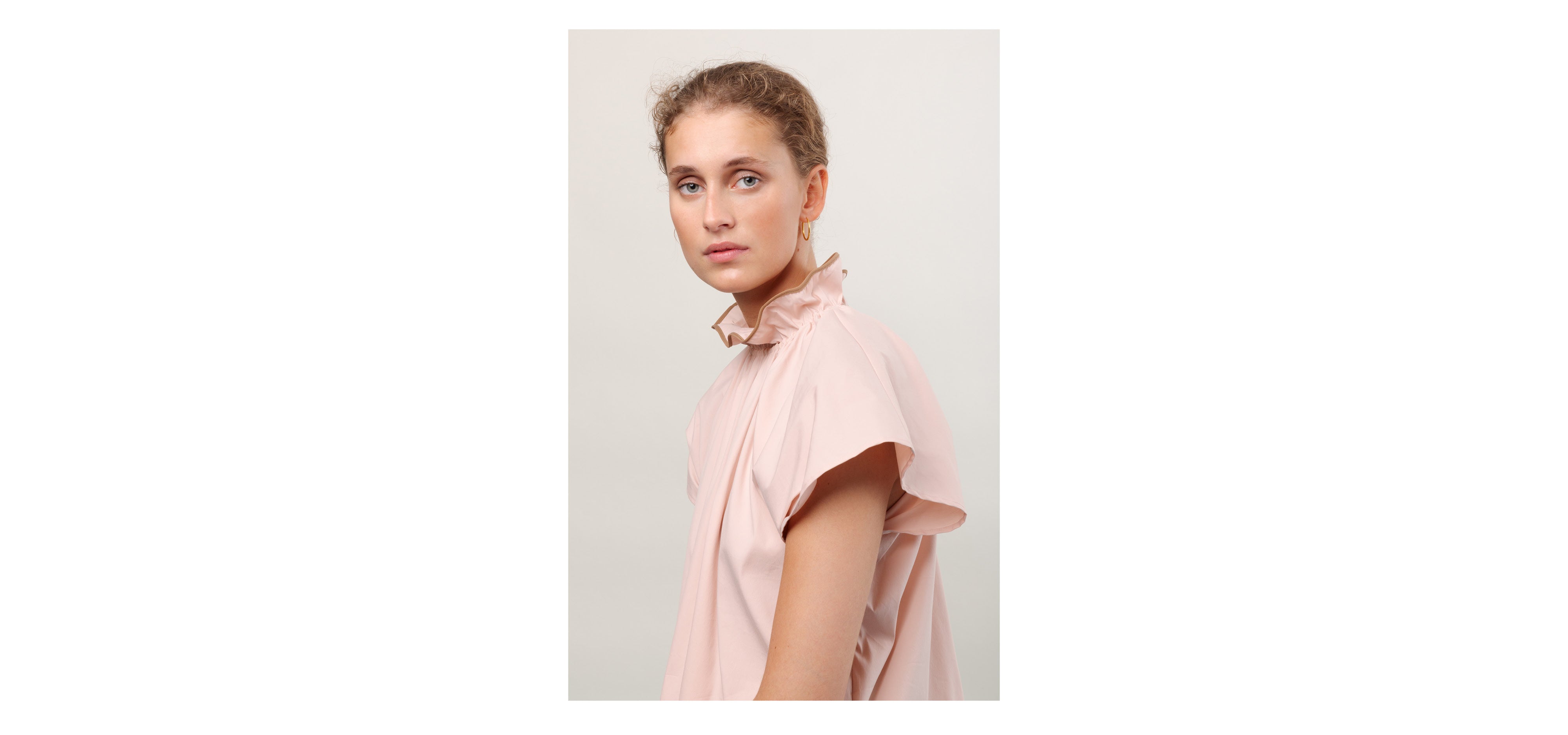 Woman in short sleeve pink shirt with frilled collar