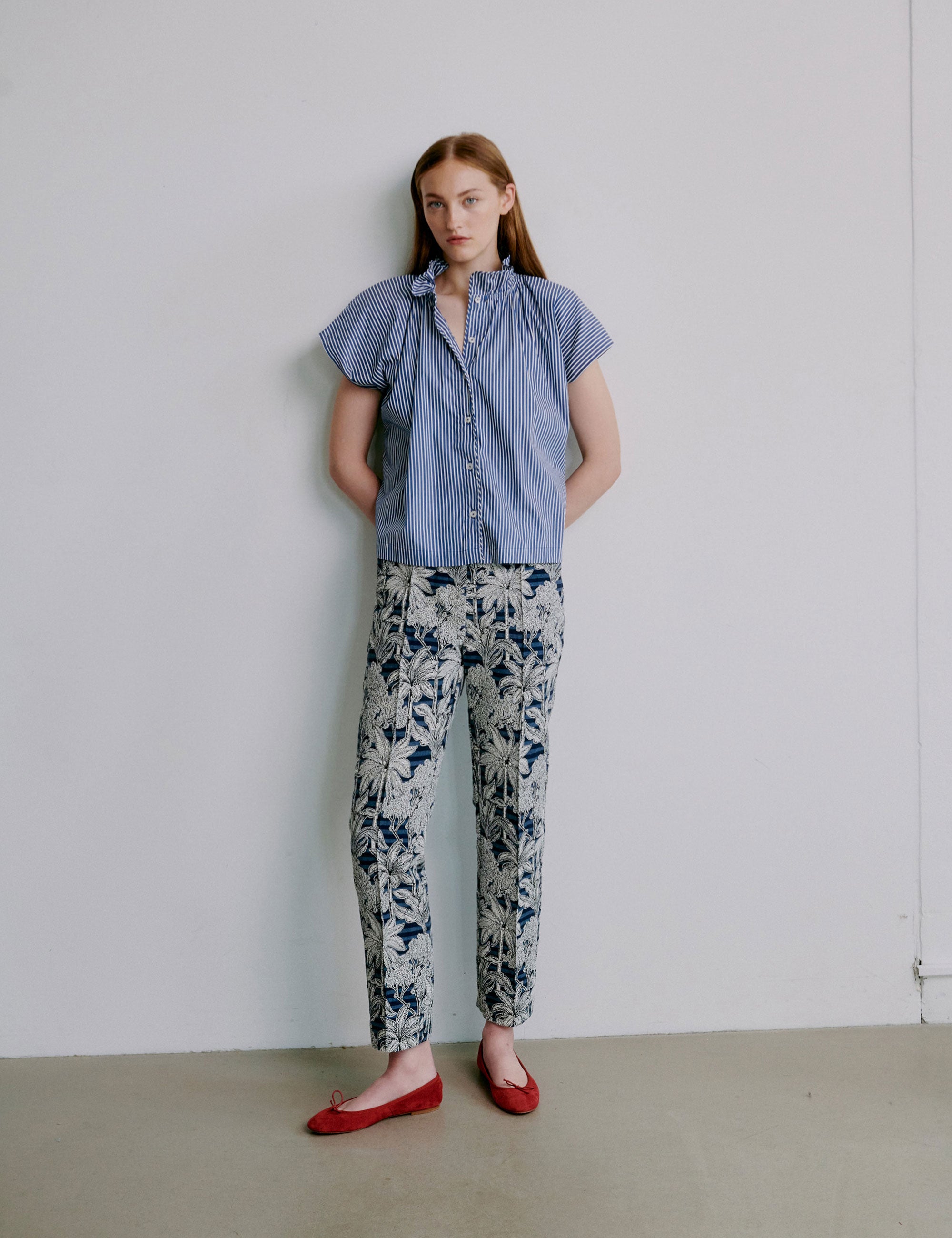 Woman wearing a blue striped shirt and floral pants
