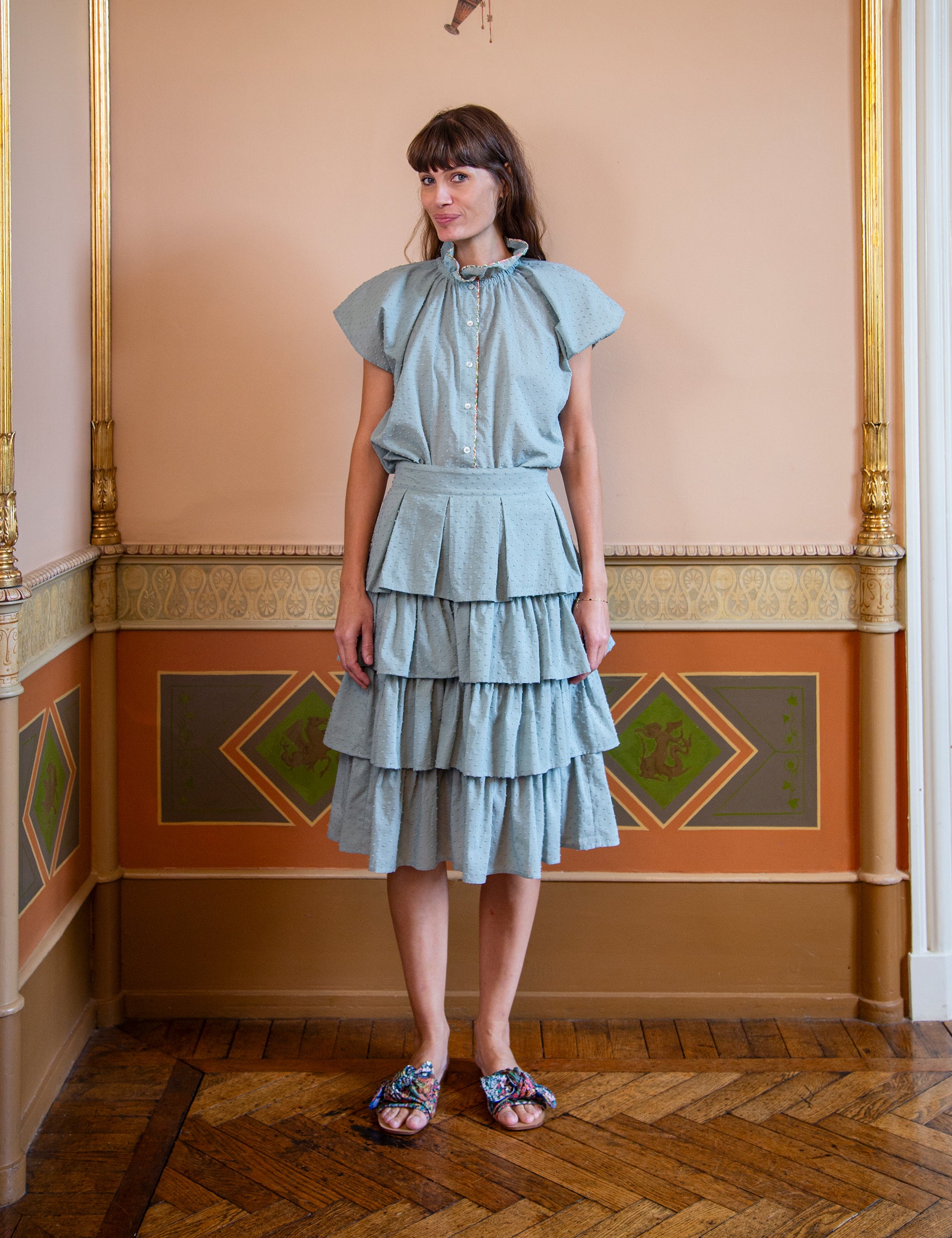 Woman wearing a light green top and layered skirt