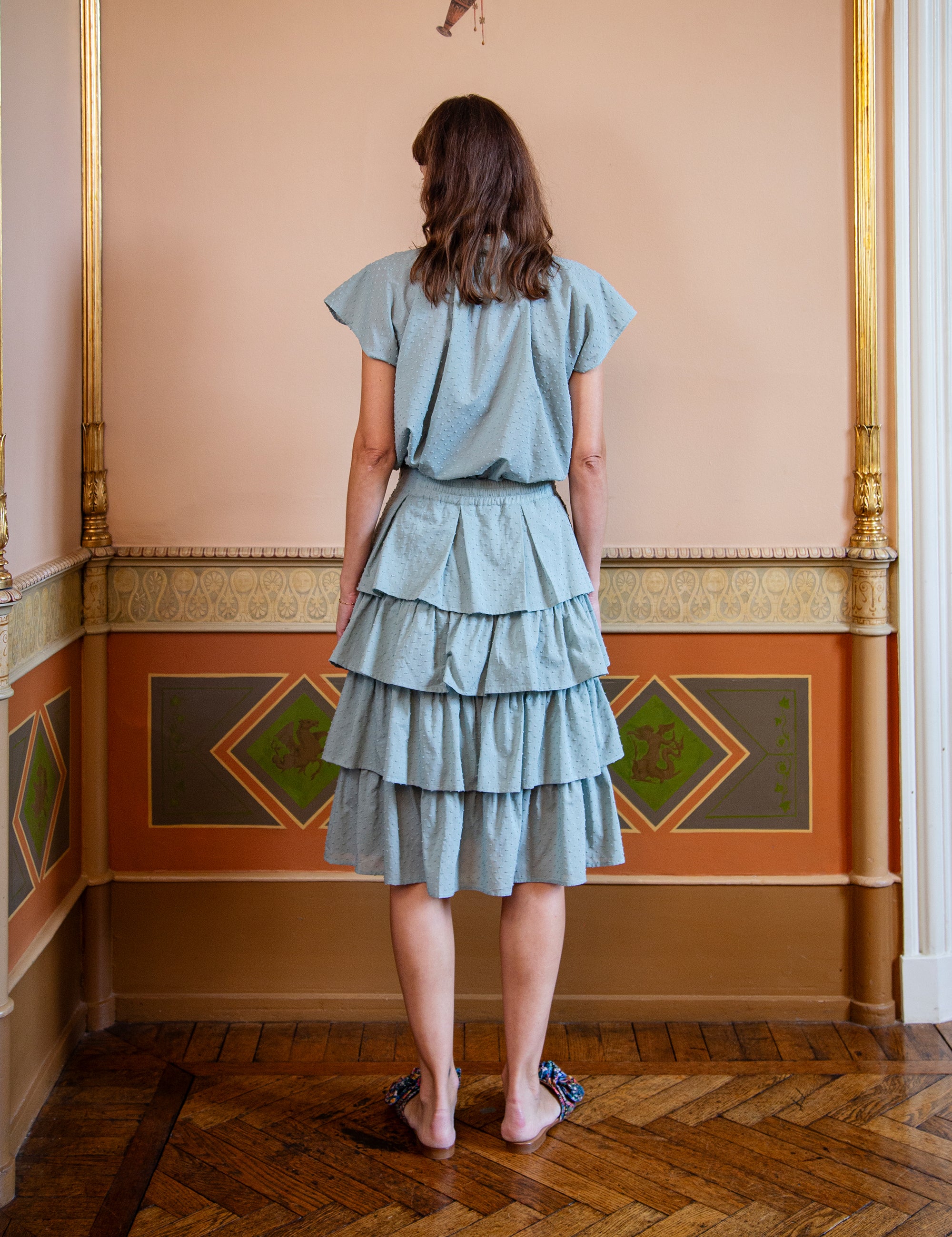 Woman wearing a light green top and layered skirt