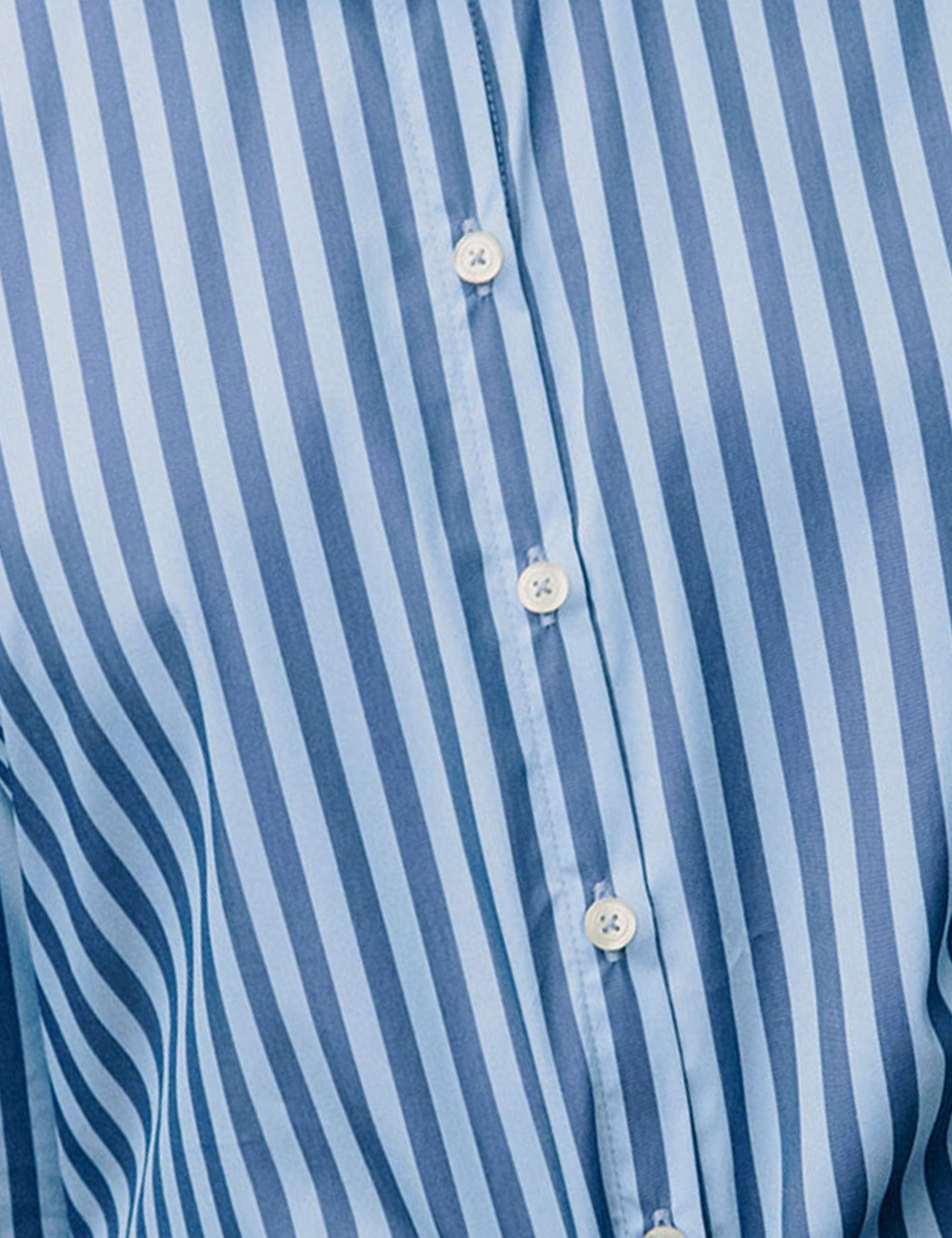 Close-up of blue and white vertical stripe fabric with button placket