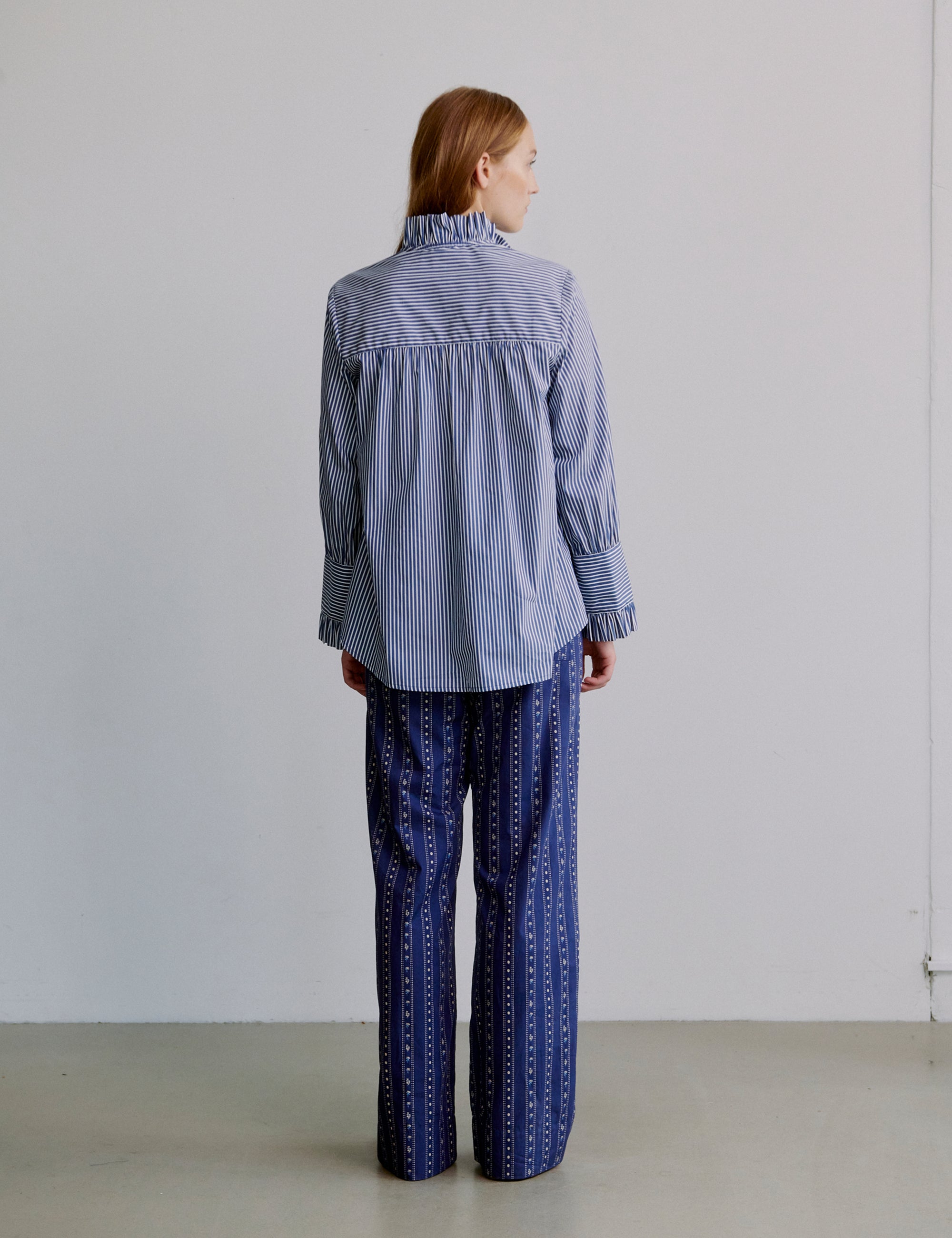 Woman wearing a blue striped shirt and blue patterned pants