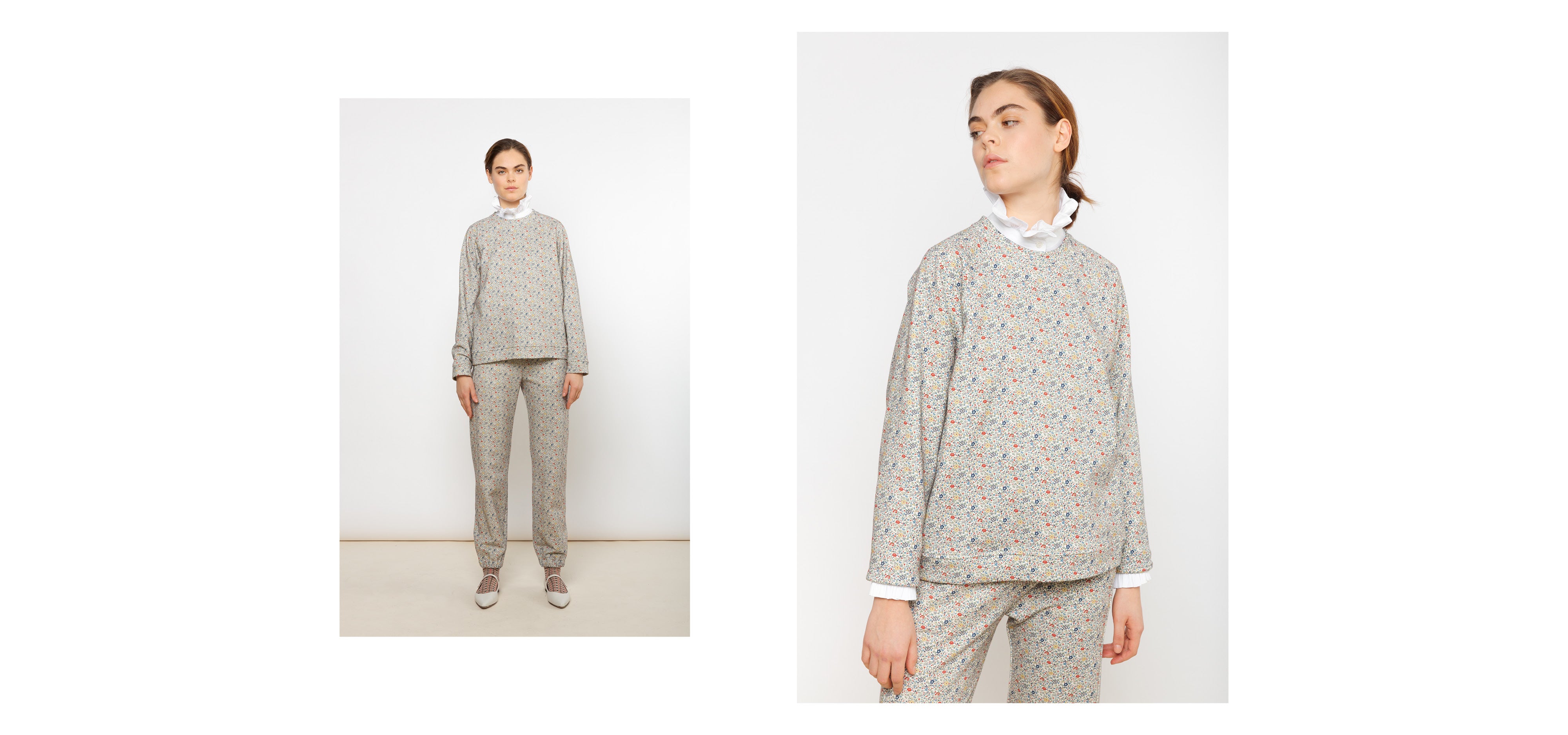 Woman in multi-colored pants and sweatshirt with small floral print and white shirt with frilled collar